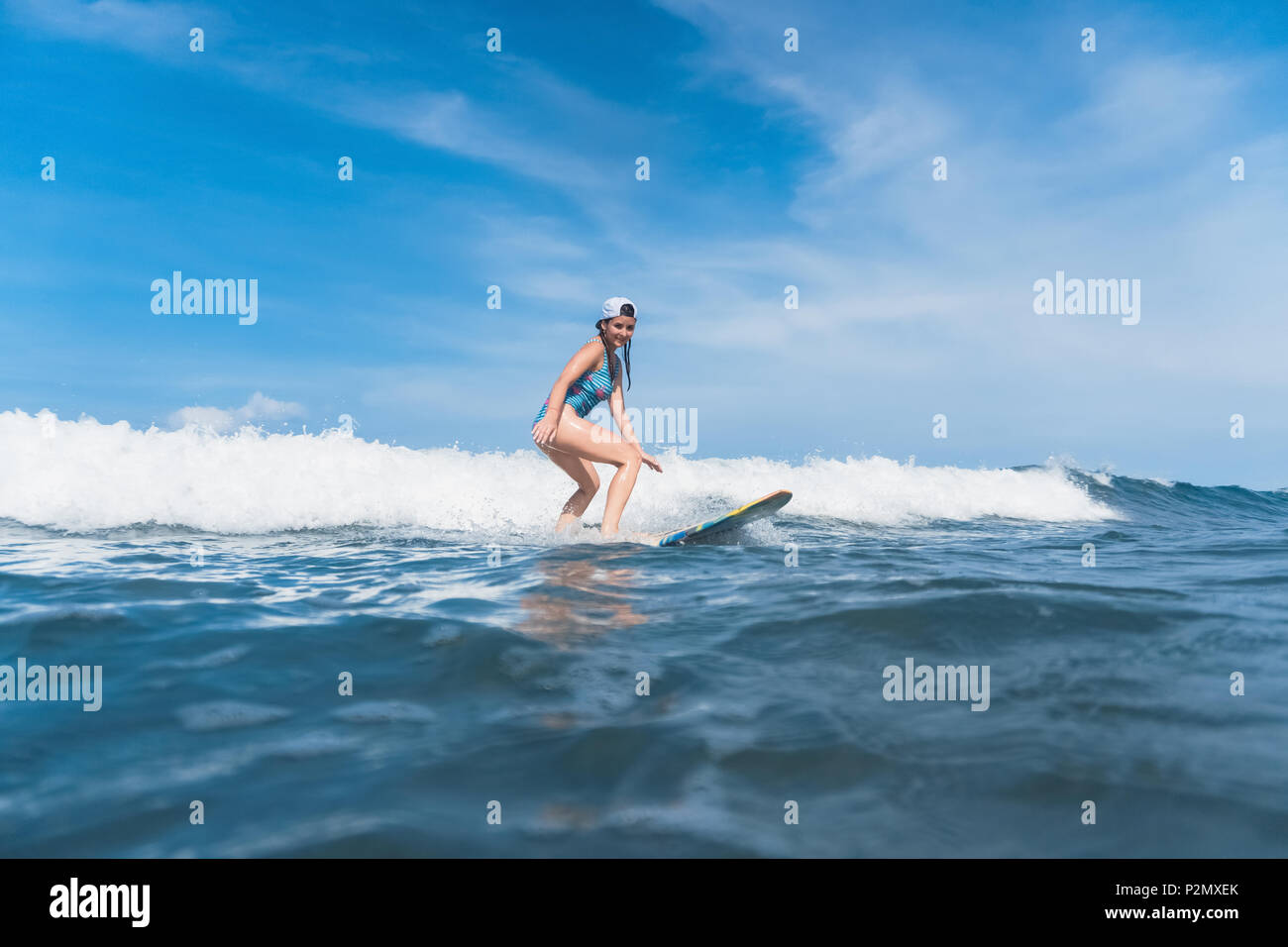 Frau im Badeanzug Surfen im Ozean Stockfoto