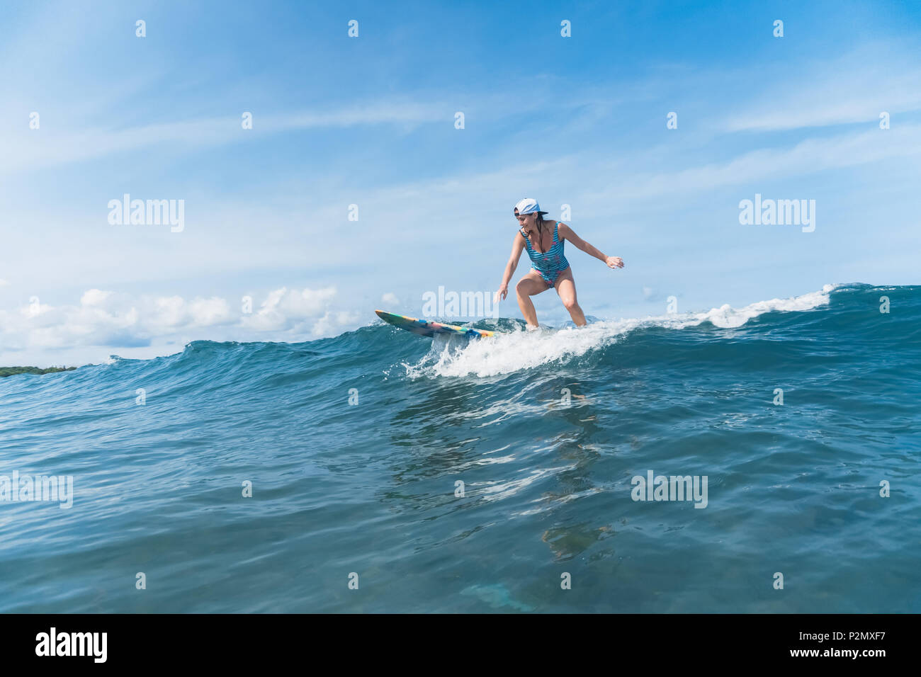 Frau im Badeanzug Surfen im Ozean Stockfoto