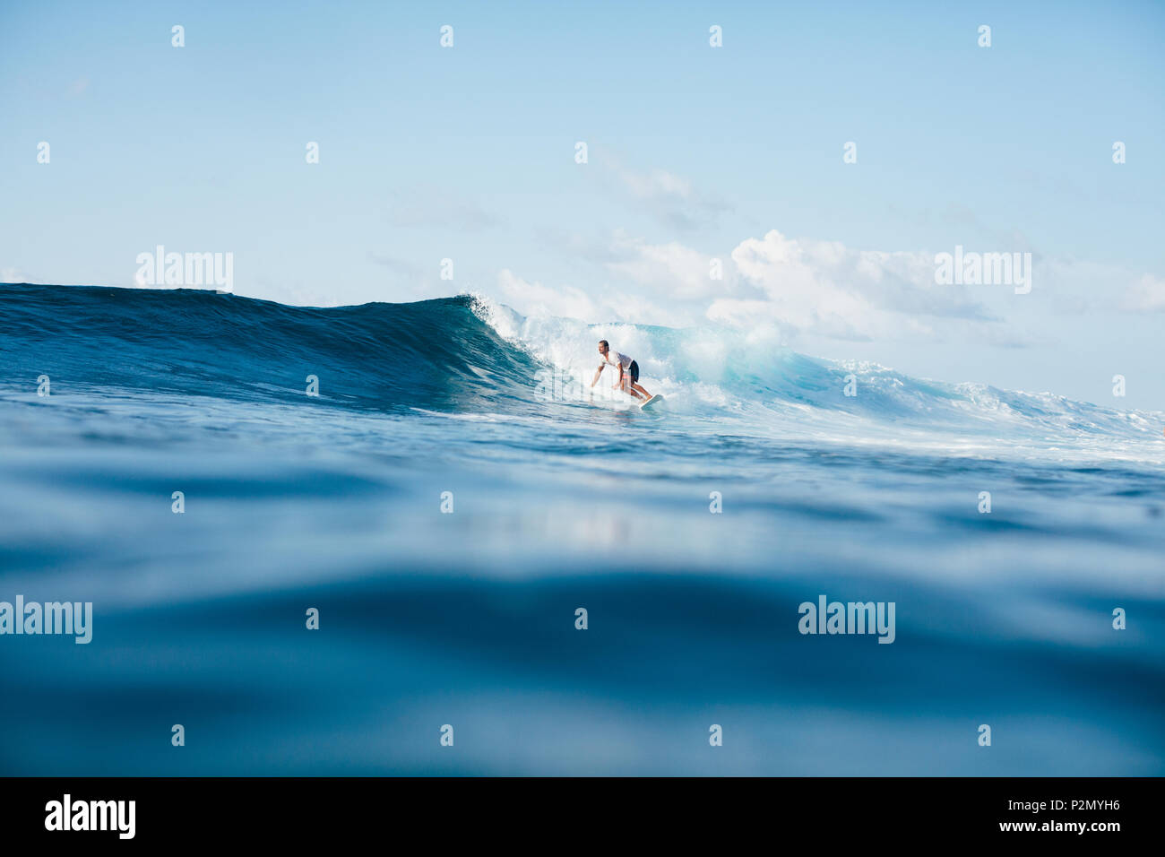 Schönen athletischen Mann surfen auf Blue Wave Stockfoto