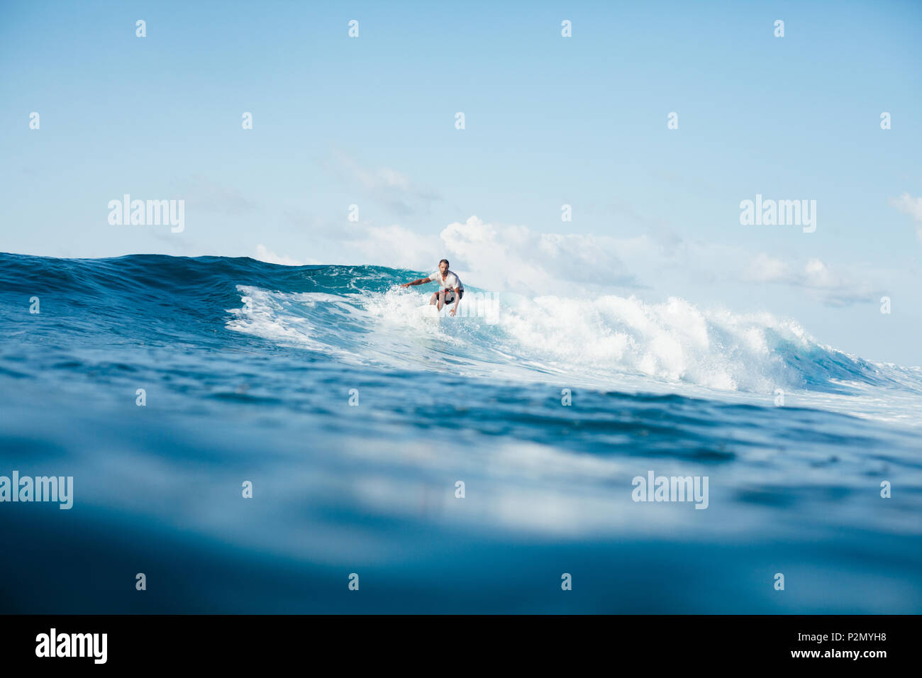 Schönen athletischen Mann Surfen auf den Wellen Stockfoto