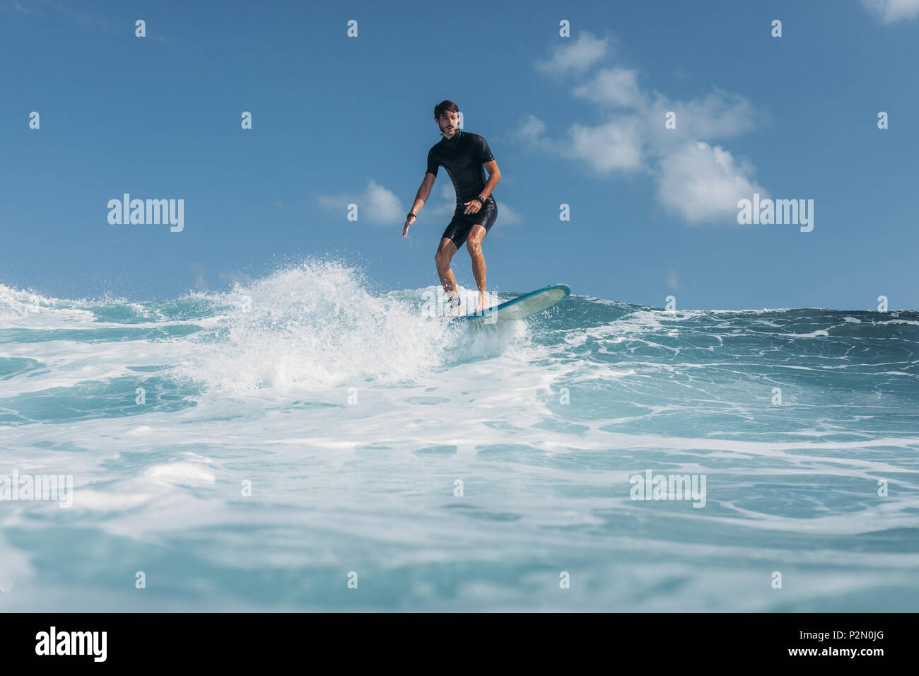 Mann auf Surfbrett surfen Welle im Ozean Stockfoto