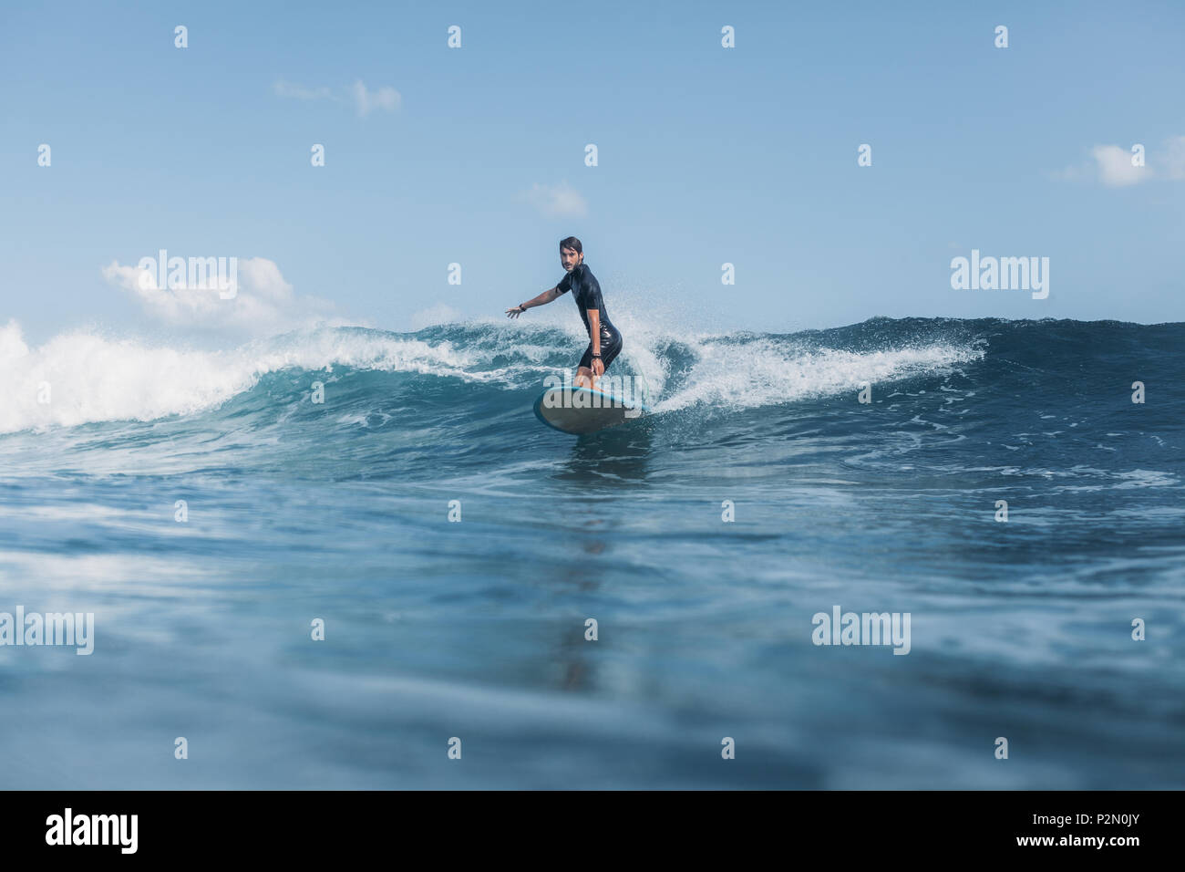 Sportler surfen Wave auf Surf Board im Ozean Stockfoto
