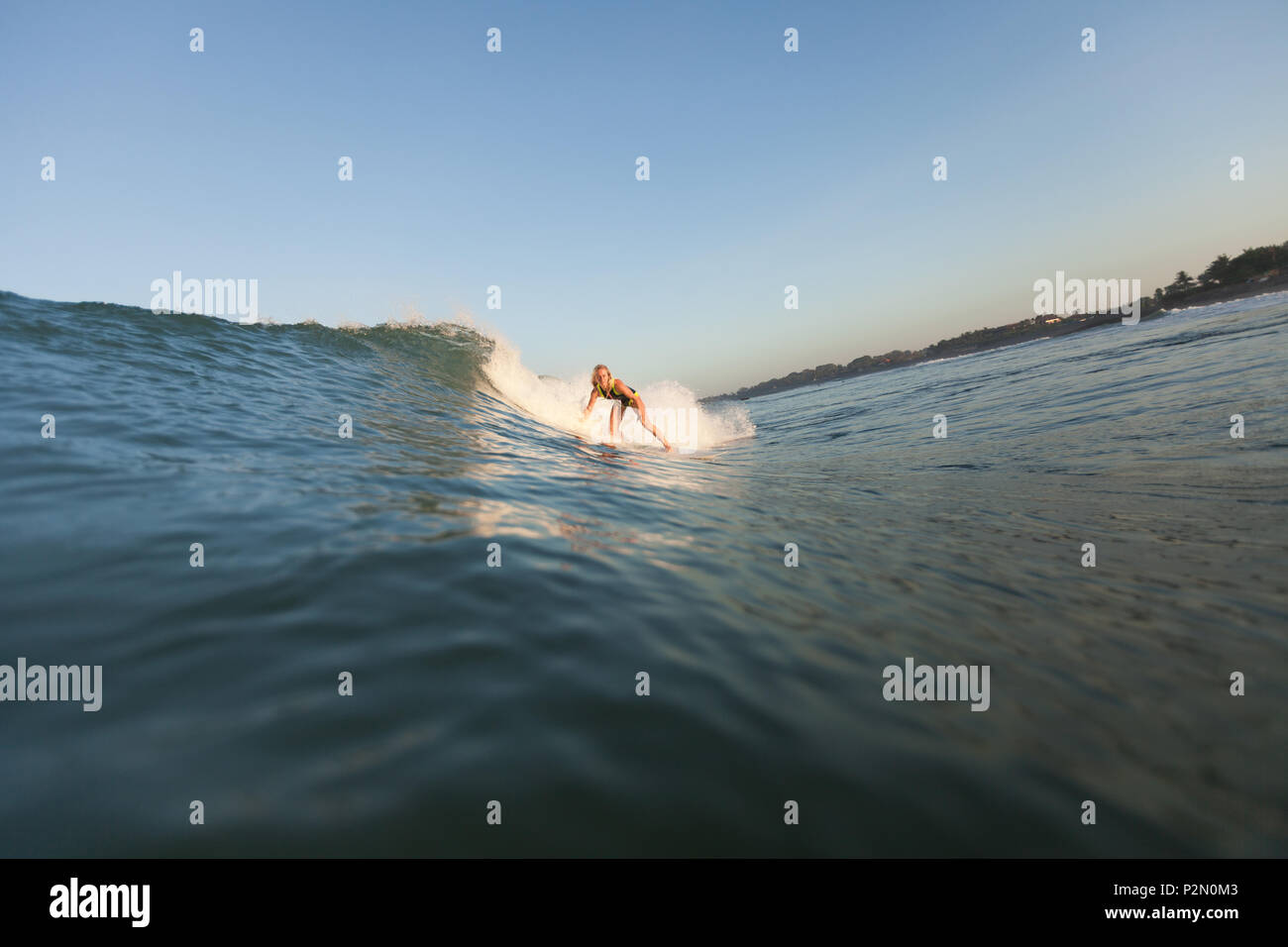 Sportlerin surft" auf der Welle auf Surf Board im Ozean Stockfoto