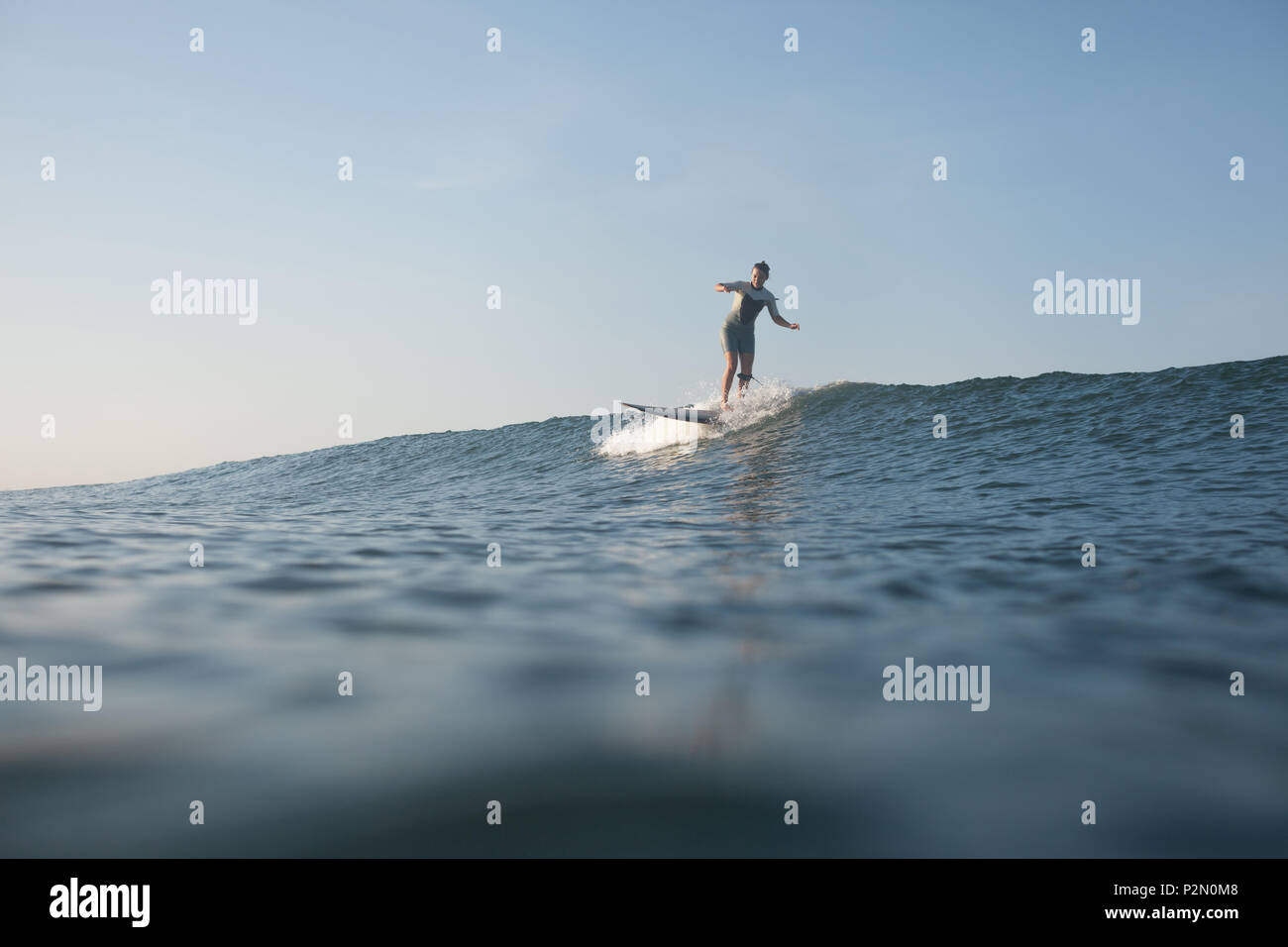 Sportlerin surft" auf der Welle auf Surf Board im Ozean Stockfoto