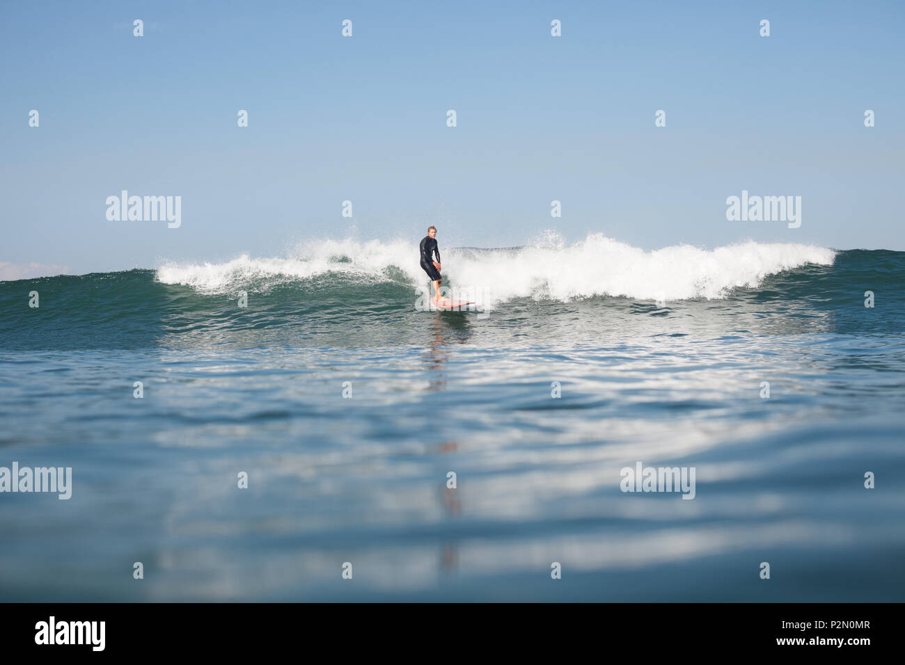 Aktive Sportler surfen Welle im Ozean Stockfoto
