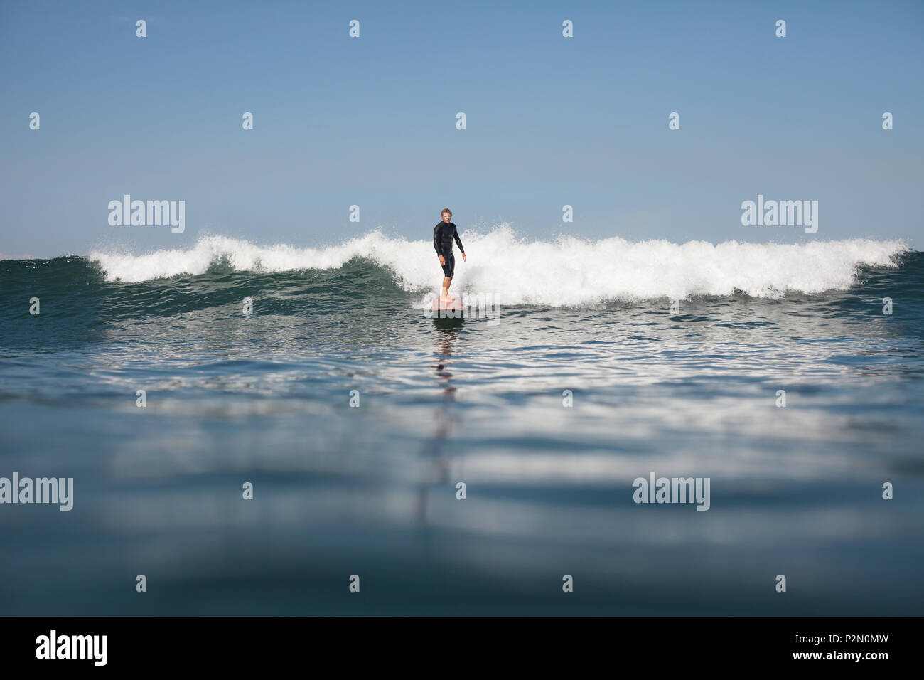 Aktiver Mann surfen Welle im Ozean Stockfoto