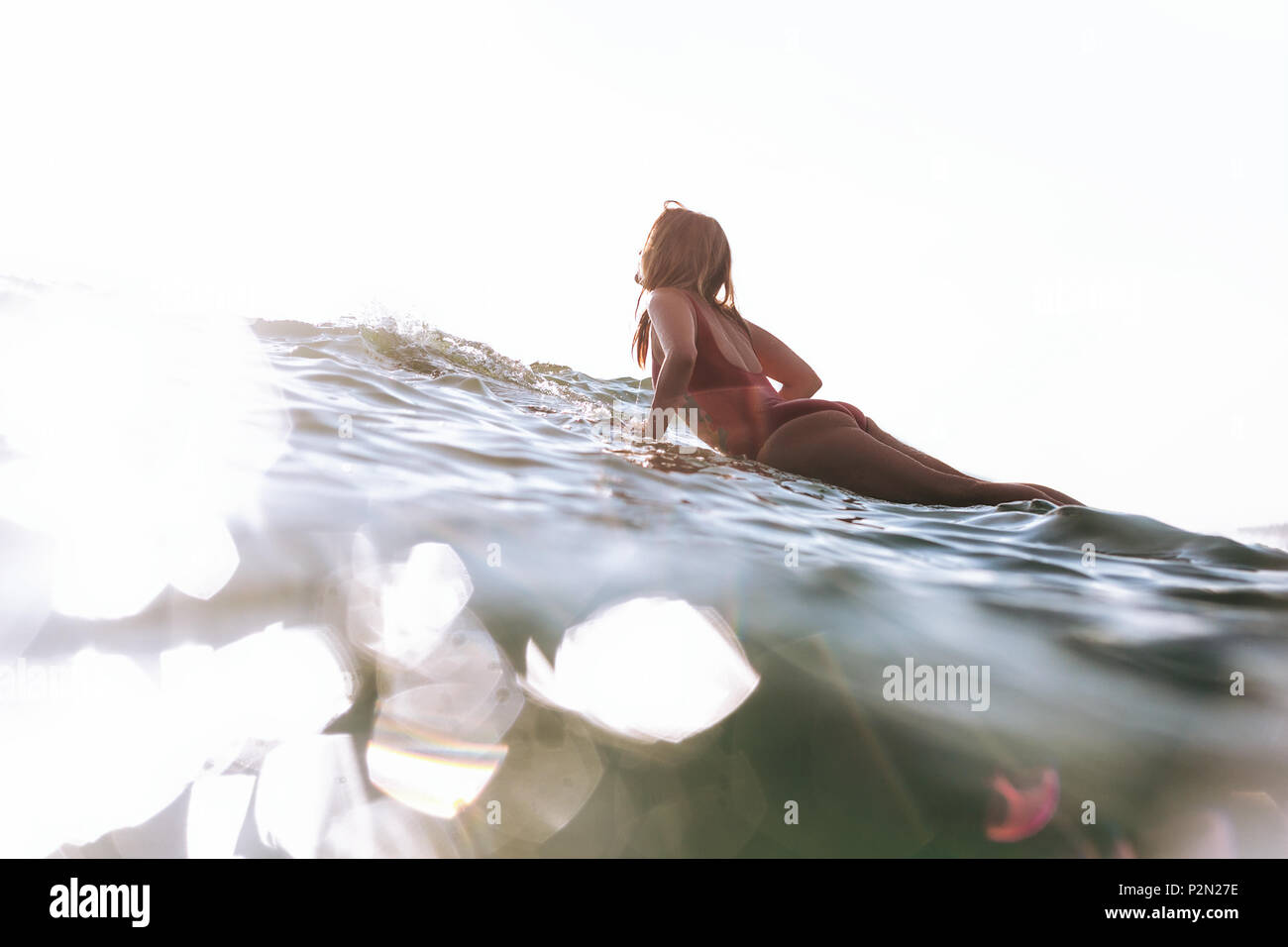Seitenansicht der Frau in Badebekleidung Surfen im Ozean Stockfoto