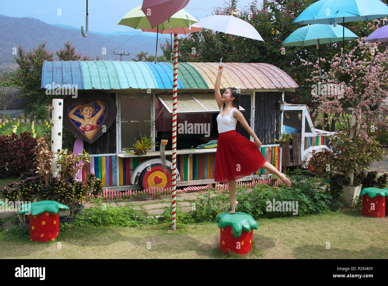 Mädchen mit Schirm hängend aus Draht Strawberry farm Pai Mae Hong Son Provinz Northern Thailand Stockfoto