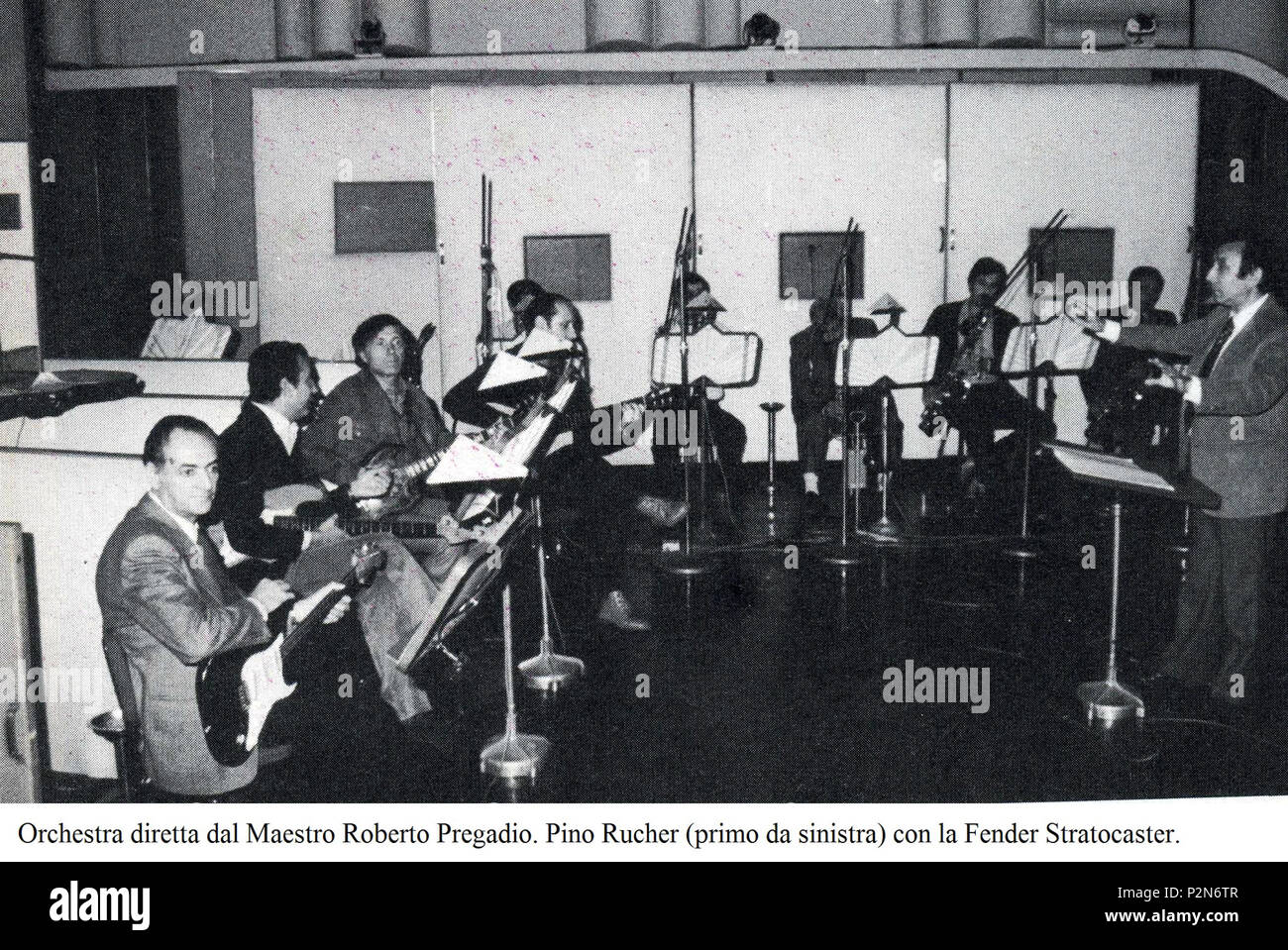 . Italiano: Orchester der RAI diretta dal Maestro Roberto Pregadio (primo da destra). Da sinistra: Pino Rucher con la Fender Stratocaster accanto Al bassista Maurizio Majorana, Sergio Coppotelli (terzo da sinistra) e Mario Gangi (Quarto Da sinistra) alla chitarra Classica. Englisch: Die RAI Orchester unter der Leitung von Meister Roberto Pregadio (1. von rechts). Von links: Pino Rucher mit seiner Fender Stratocaster Neben Bassist Maurizio Majorana, Sergio Coppotelli (dritter von links) und Mario Gangi (vierter von links) auf der klassischen Gitarre. 1981. Der Fotograf ist unbekannt 66 Orchester der RAI dirett Stockfoto
