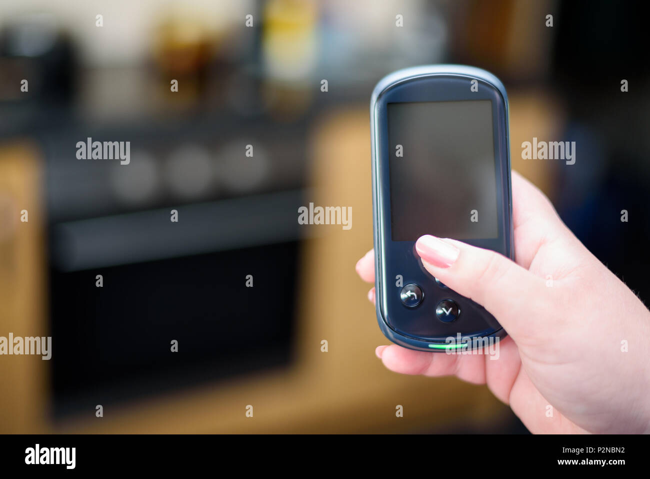 Frau mit einem inländischen Energy Smart Meter Einheit in einer Küche Stockfoto
