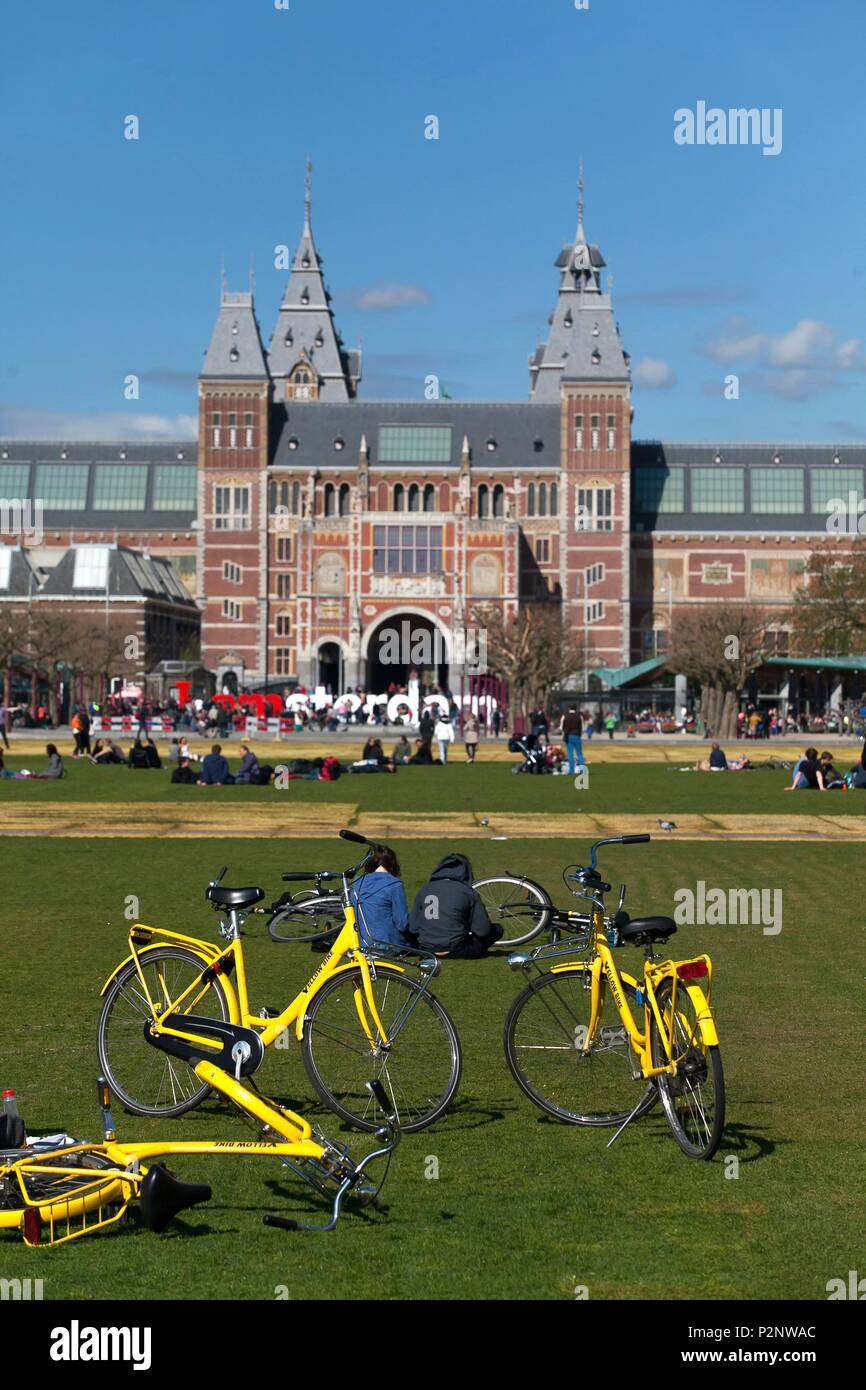 Niederlande, Provinz Nord Holland, Amsterdam, Menschen sind Erholung und Spaß auf dem Rasen der Museumplein Park, im Hintergrund das Rijksmuseum Stockfoto