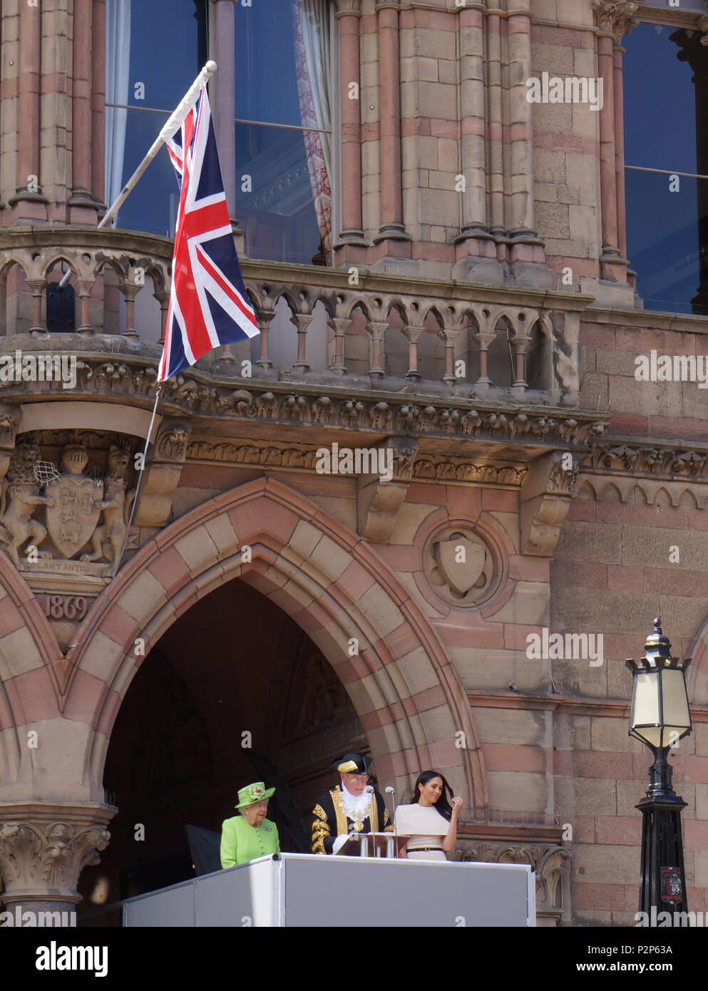 Ihre Majestät die Königin, und die Herzogin von Sussex, lauschen Sie dem Oberbürgermeister der Stadt Chester Rede, wie sie auf dem Balkon von Chester Rathaus vor eine grosse, einladende Masse stehen. Sie waren in der Stadt Chester für die offizielle Eröffnung des Storyhouse komplex. Dies war Meghan Markle, die Herzogin von Sussex erste offizielle Engagement. Stockfoto
