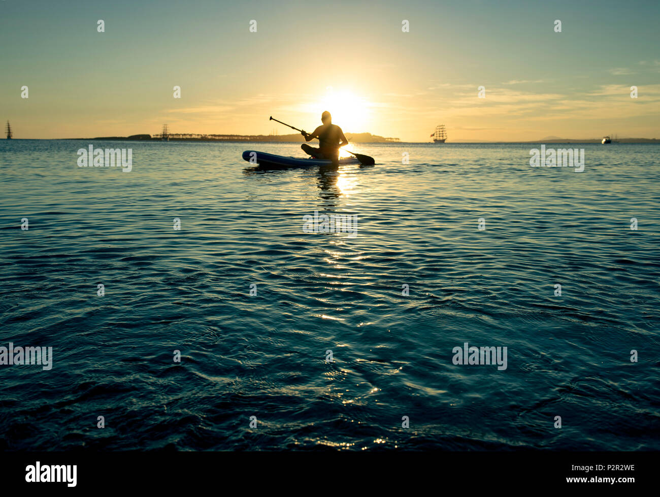 Mann Paddle Boarding bei Sonnenuntergang am Strand von Punta del Este, Uruguay. Stockfoto