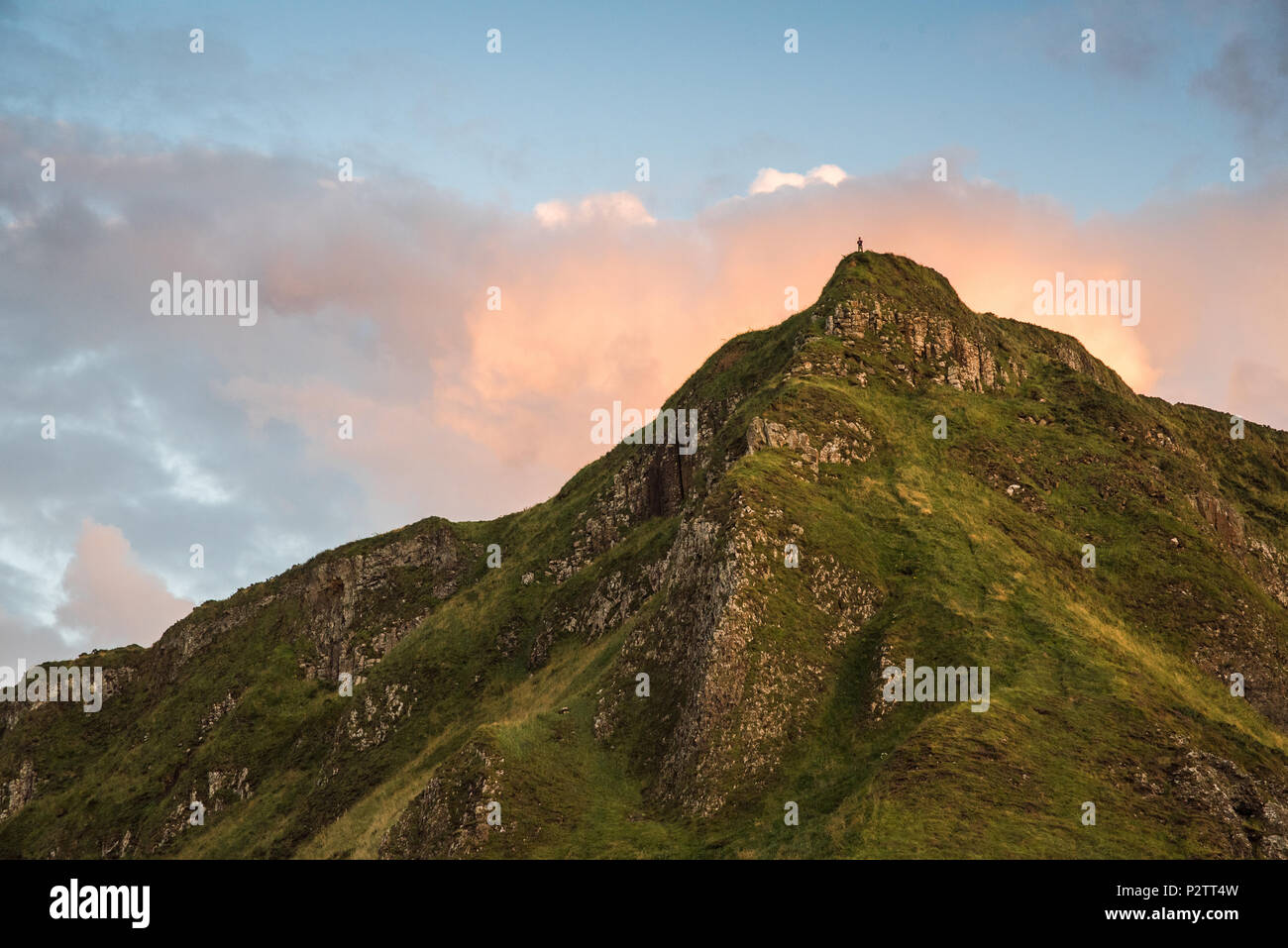 Landschaft Blick auf eine entfernte Person an der Spitze eines Berges in der Nähe von Giants Causeway in Nordirland. Stockfoto