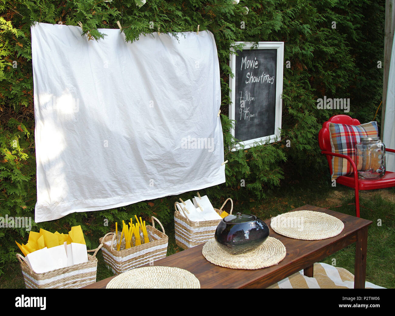 Weißes Blatt bereit für einen Kinoabend im Freien mit Nahrungsmitteln und Stühlen Stockfoto