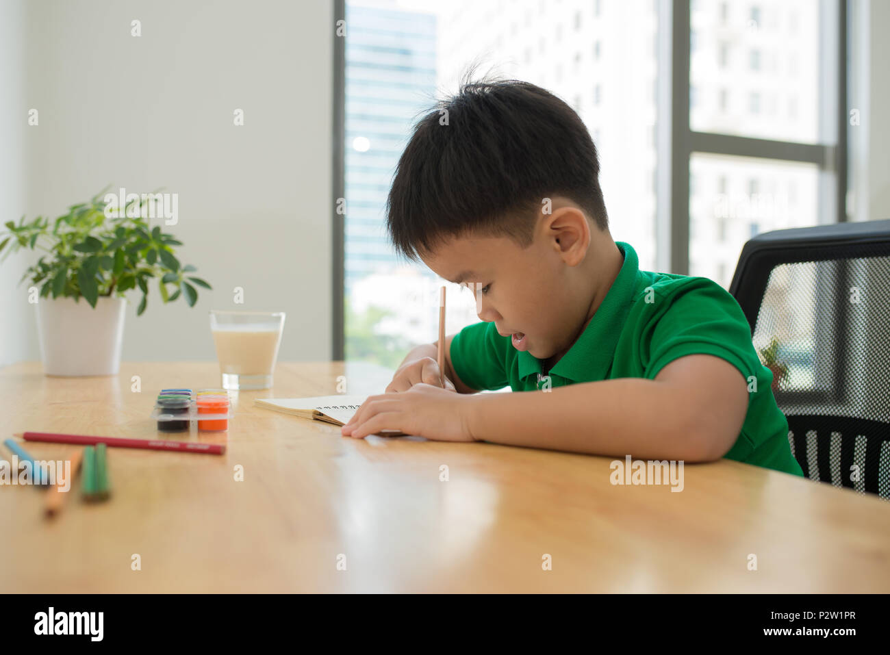 Nett lächelnden jungen Hausaufgaben, Malvorlagen, Schreiben und Malen. Kinder malen. Kinder ziehen. Vorschüler mit Büchern in der Bibliothek. Bunte pen Stockfoto