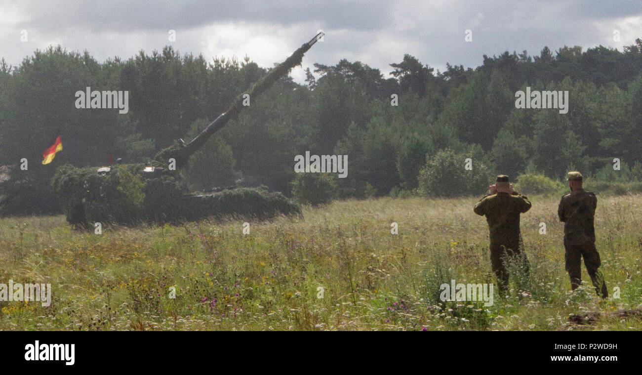 Deutschen und litauischen Soldaten stehen neben einem neuen Litauischen Haubitze im Vorgriff auf Maßnahmen von einem in der Nähe gelegenen Deutschen Haubitze während der Übung Flaming Donner, 2. August 2016 Kairiai, Litauen. Flaming Thunder ist eine zwei-wöchigen multinationale Feuer Koordinierung und kombinierte Waffen Feuer Interoperabilität zwischen der NATO Fire Support Einheiten zu verbessern und zu trainieren und Joint Fire Support mit der Integration der Manöver Elemente führen, Luftnahunterstützung und Nahkampf angreifen. Die Soldaten vom 1.Bataillon, 41 Field Artillery Regiment, 1 Armor Brigade Combat Team, 3rd Infantry Divisi Stockfoto