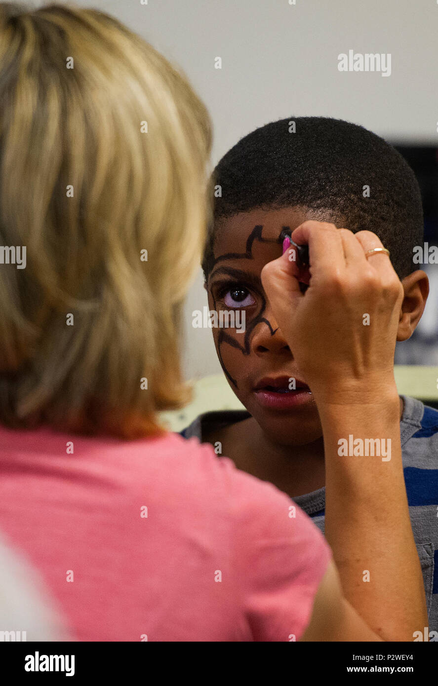 Ein freiwilliger malt das Gesicht des sechs Jahre alten Roderick Burse zu einem anti-Mobbing Veranstaltung namens Stop Mobbing, Give Peace A Chance, gehalten in der religiösen Erziehung in Wright-Patterson Air Force Base, Ohio, Aug 2, 2016. Burse ist der Sohn von Ronneja und Staff Sgt. Roderick Burse jr., 435Th Supply Chain Operations Squadron. (U.S. Air Force Foto von R.J. Oriez) Stockfoto