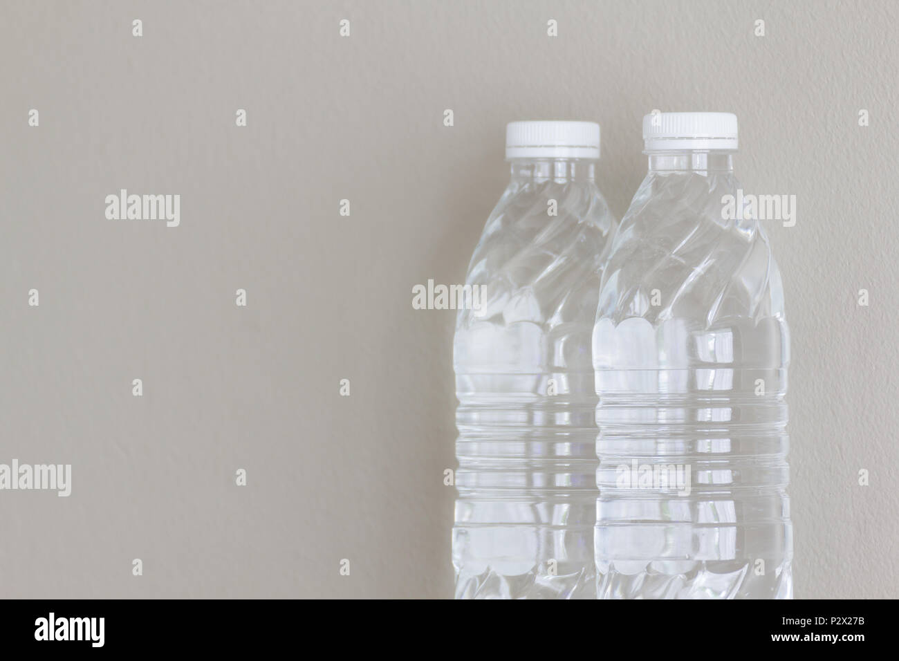 Reines Wasser in klaren Flaschen mit grauen Hintergrund. Stockfoto