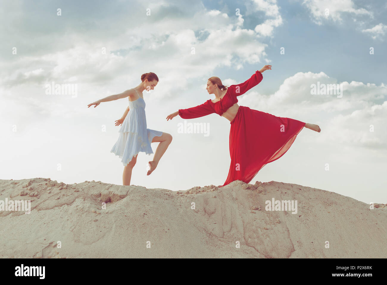 Junge Tänzerinnen tanzen in der Wüste im Sand. Stockfoto