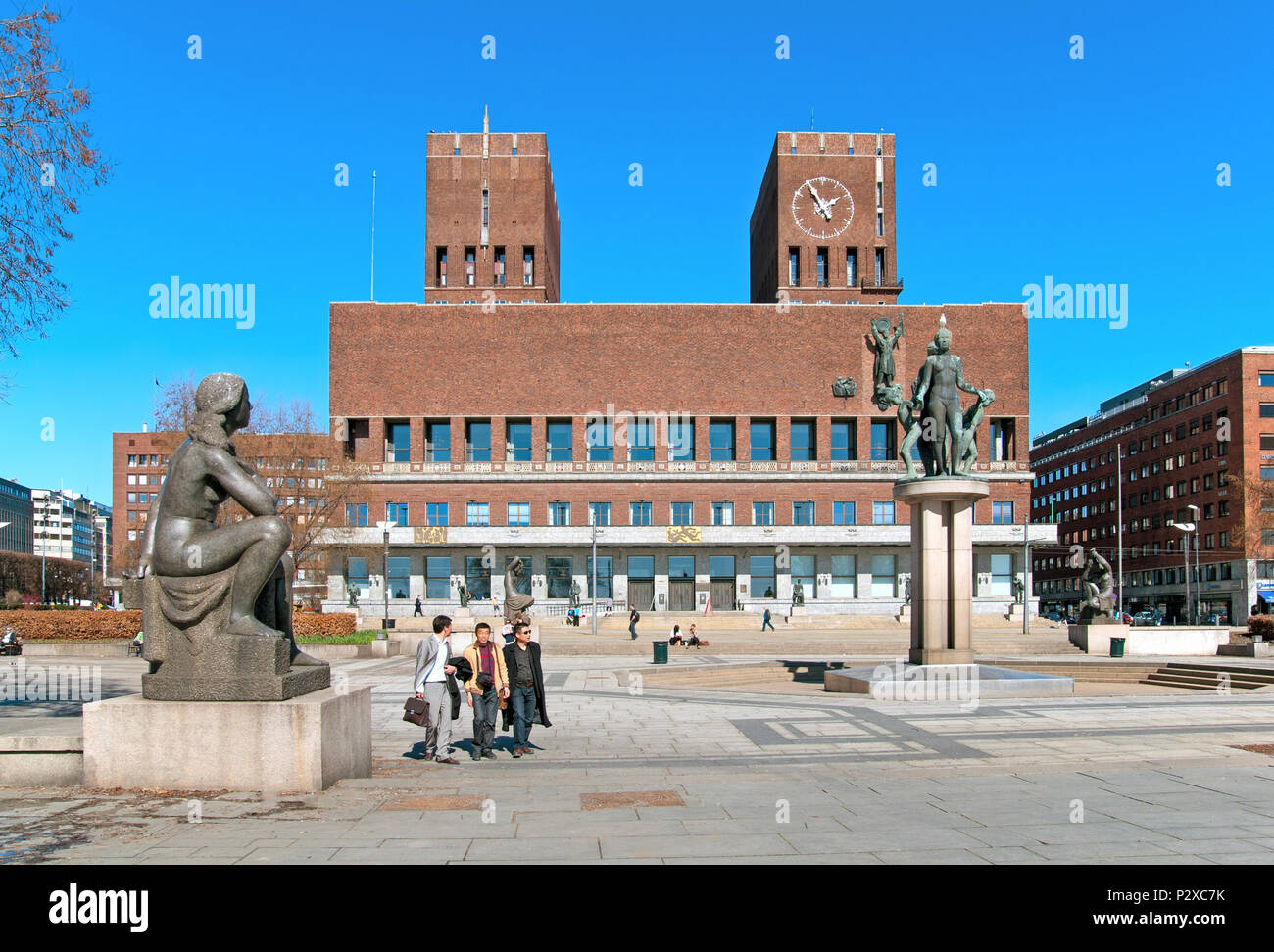 OSLO, Norwegen - 12 April 2010: Ausländische Touristen vorbei an der Skulpturen auf dem Platz vor dem Rathaus Stockfoto