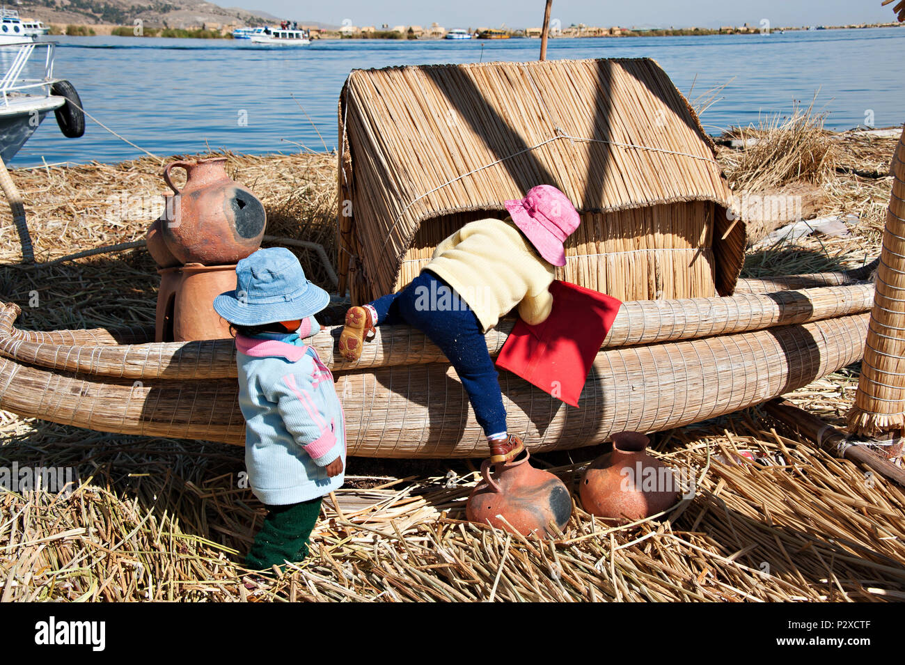 Lokaler Bewohner Kinder auf Klettern zu einem Reed Boot auf Uros Island auch als schwimmende Inseln in Peru bekannt, Südamerika Stockfoto