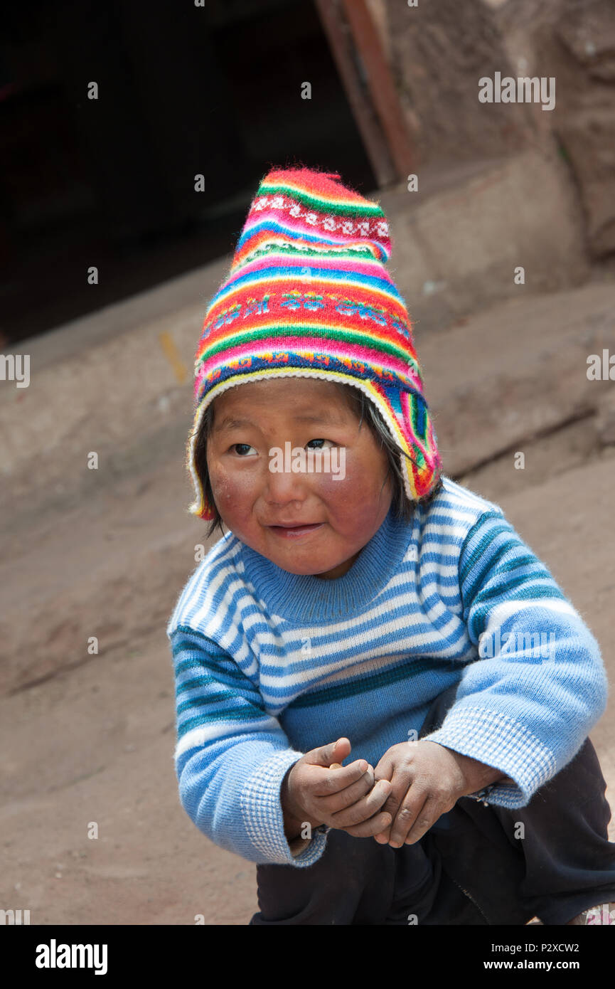 Eine schlechte lokale Kind stellt für die Touristen in der Hoffnung, Geld oder Süßigkeiten zu erhalten. Insel Taquile, Puno, Peru, Südamerika Stockfoto