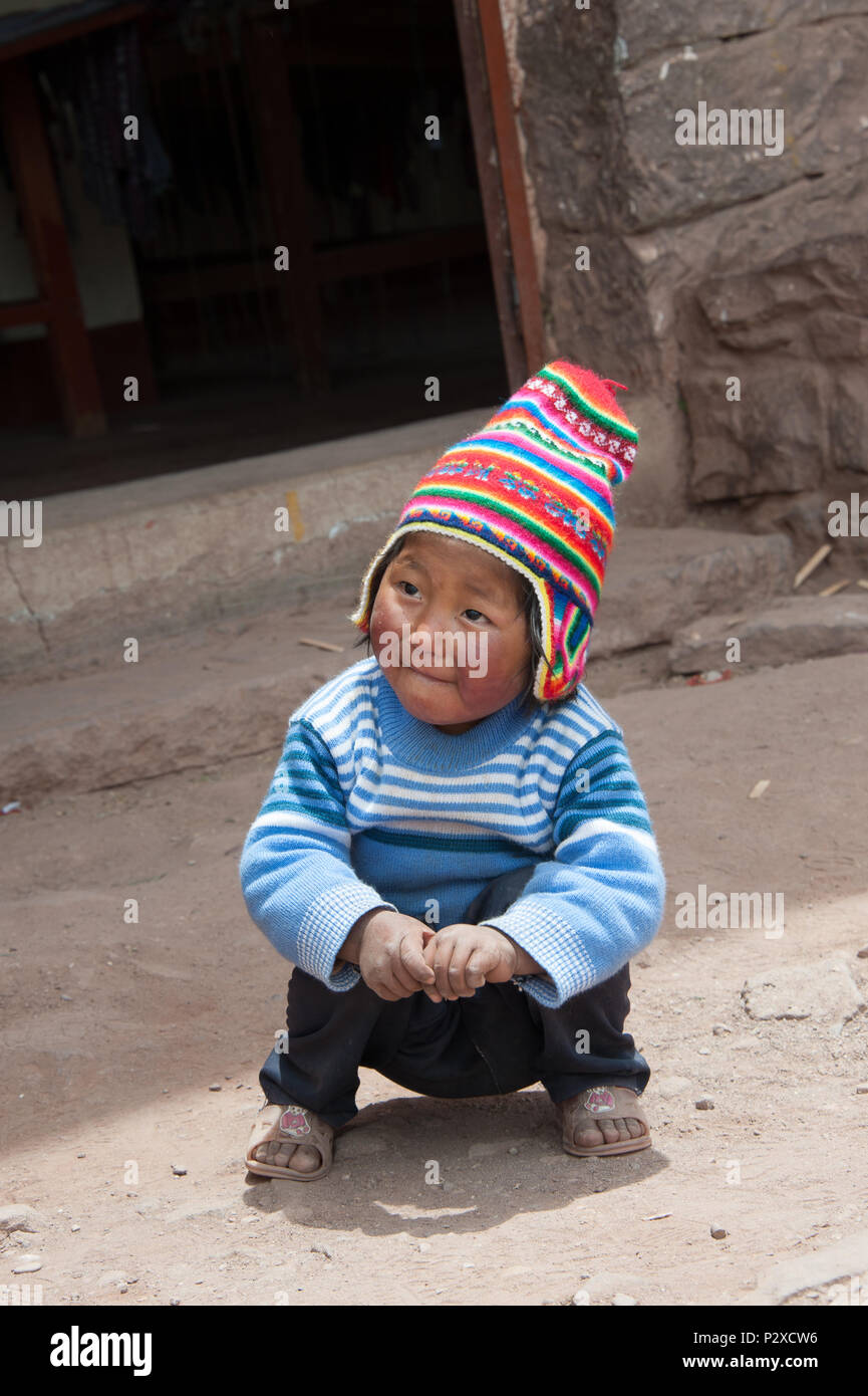 Eine schlechte lokale Kind stellt für die Touristen in der Hoffnung, Geld oder Süßigkeiten zu erhalten. Insel Taquile, Puno, Peru, Südamerika Stockfoto