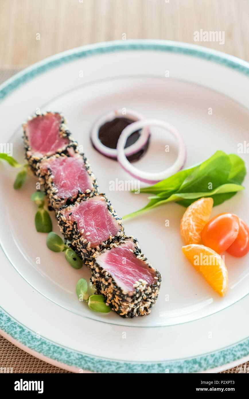 Thunfisch mit Sesam mit grünem Salat auf weiße Platte Stockfoto