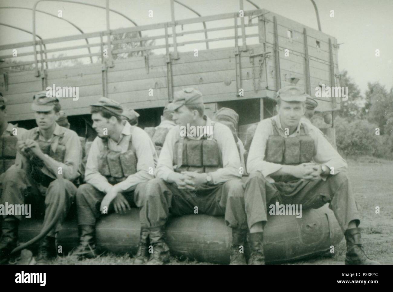 Die tschechoslowakische SOZIALISTISCHE REPUBLIK - circa 1970 s: Retro Foto zeigt junge Männer (Soldaten) im Sommer. Soldaten pose mit einem Riemen (Weste) und auf dem Gummi Boot sitzen. Vintage Fotografie. Stockfoto