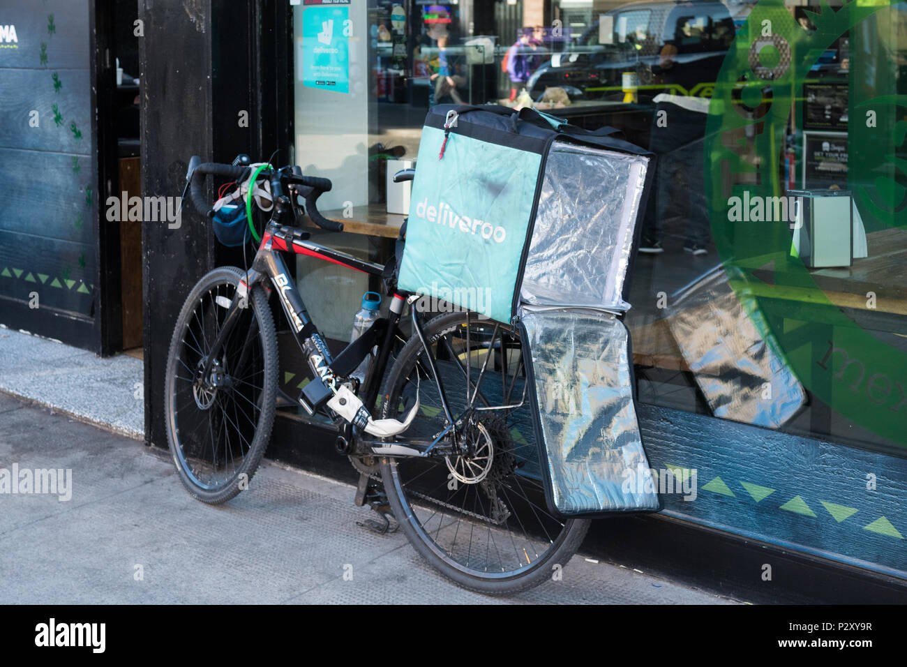 Deliveroo Fahrrad ausserhalb Restaurant in Glasgow, Schottland, Großbritannien Stockfoto