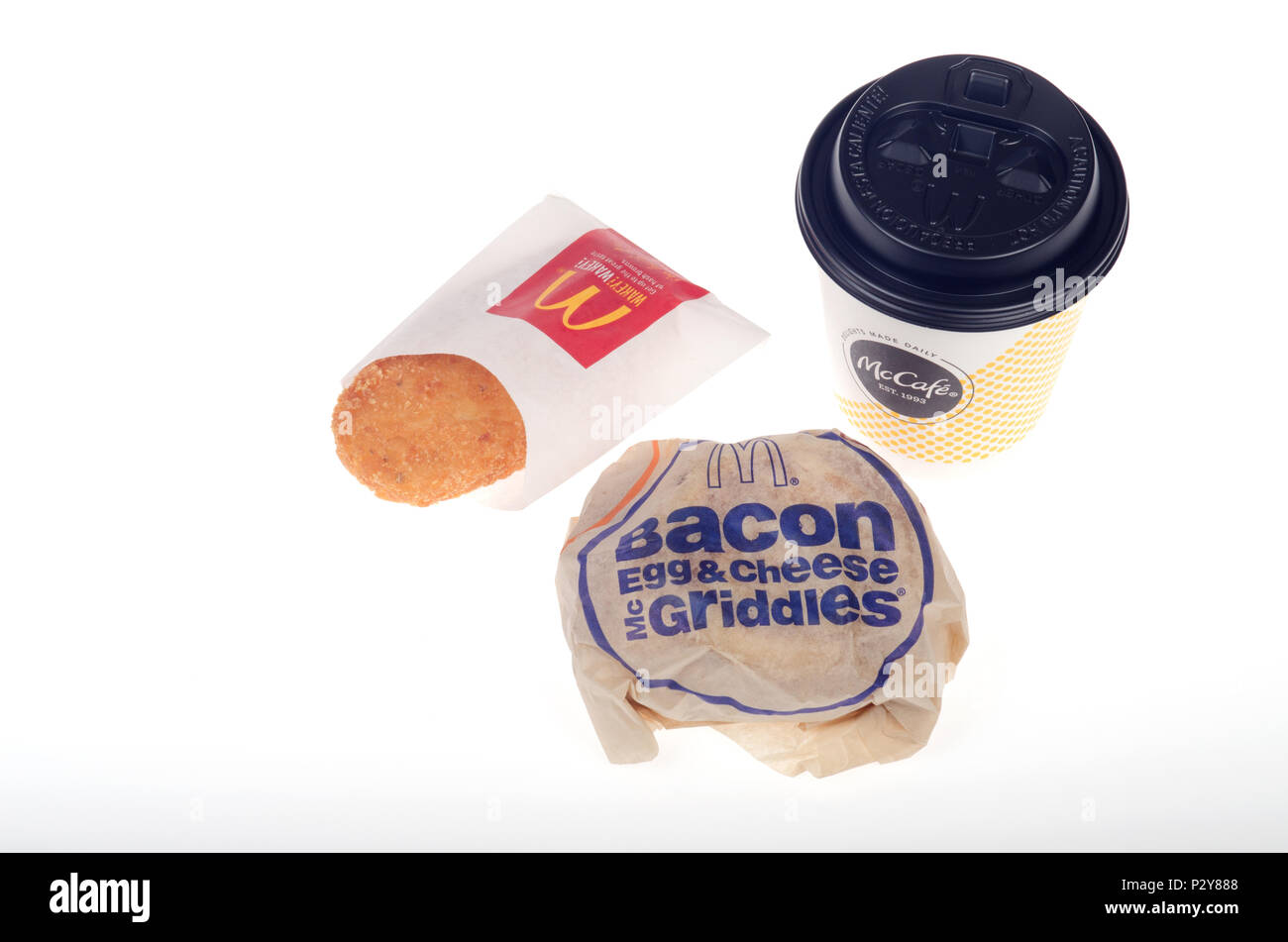 McDonald's Frühstück mit Speck, Ei und Käse McGriddle mit Hash Brown Kartoffel Patty und Tasse Kaffee auf weißem Hintergrund Stockfoto