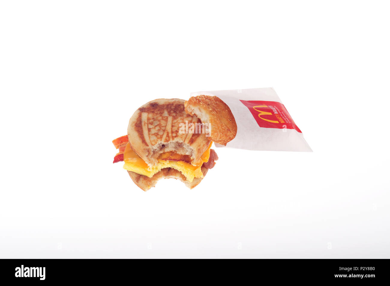 McDonald's Speck, Ei und Käse McGriddle mit Hash Brown patty auf Verpackung mit Bissen genommen Stockfoto