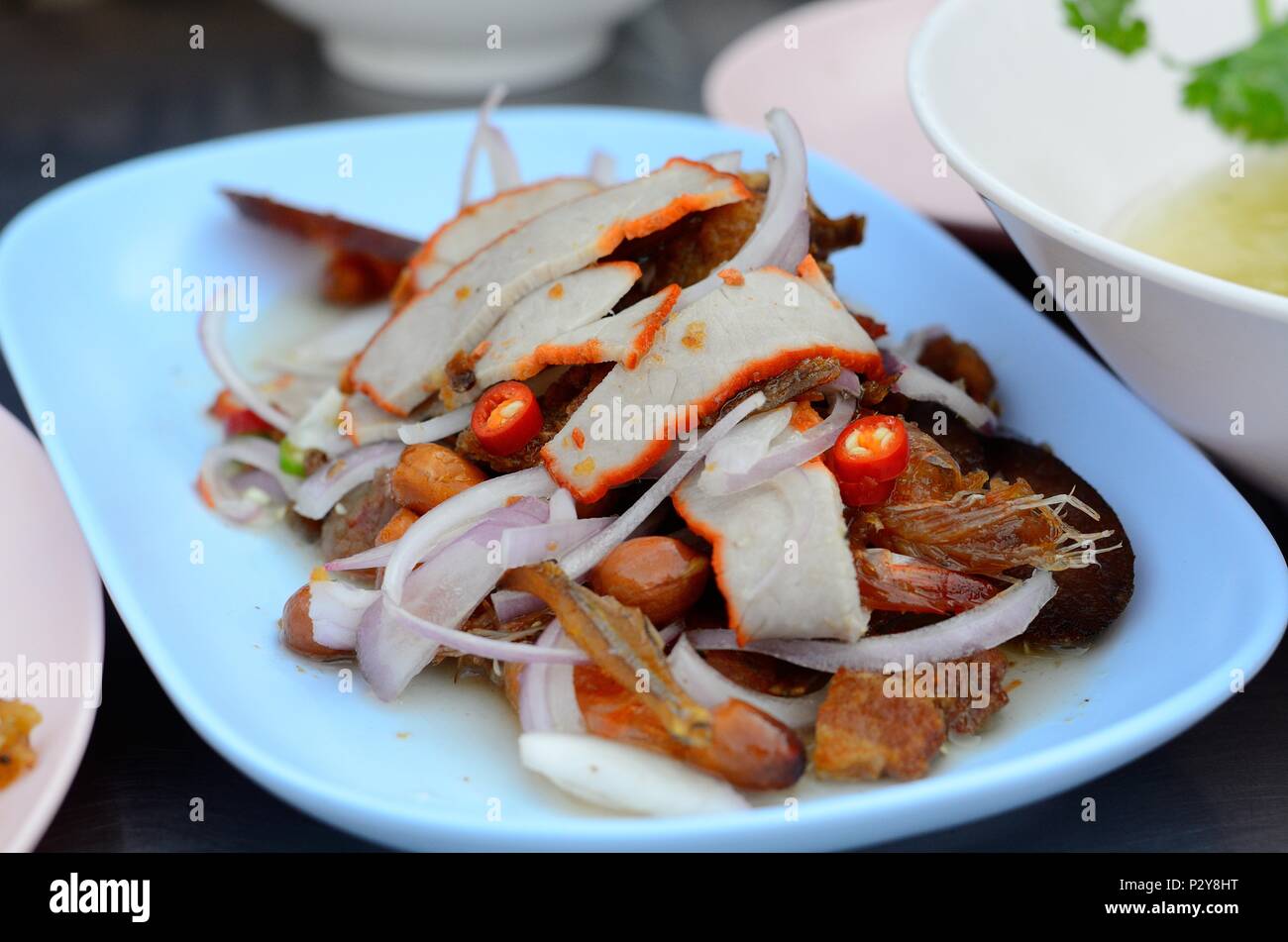 Knusprig gebraten mit roten Schweinefleisch und Boden Mutter würzigen Salat Stockfoto