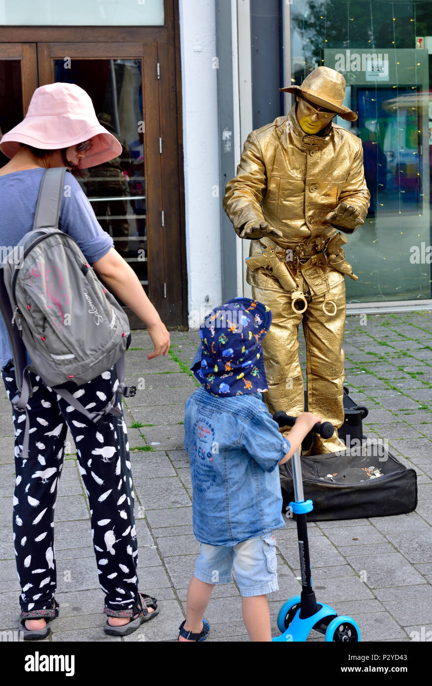 Gold cowboy lebende Statue Interaktion mit Frau und junge Zuschauer, zentrale Bristol, Großbritannien Stockfoto