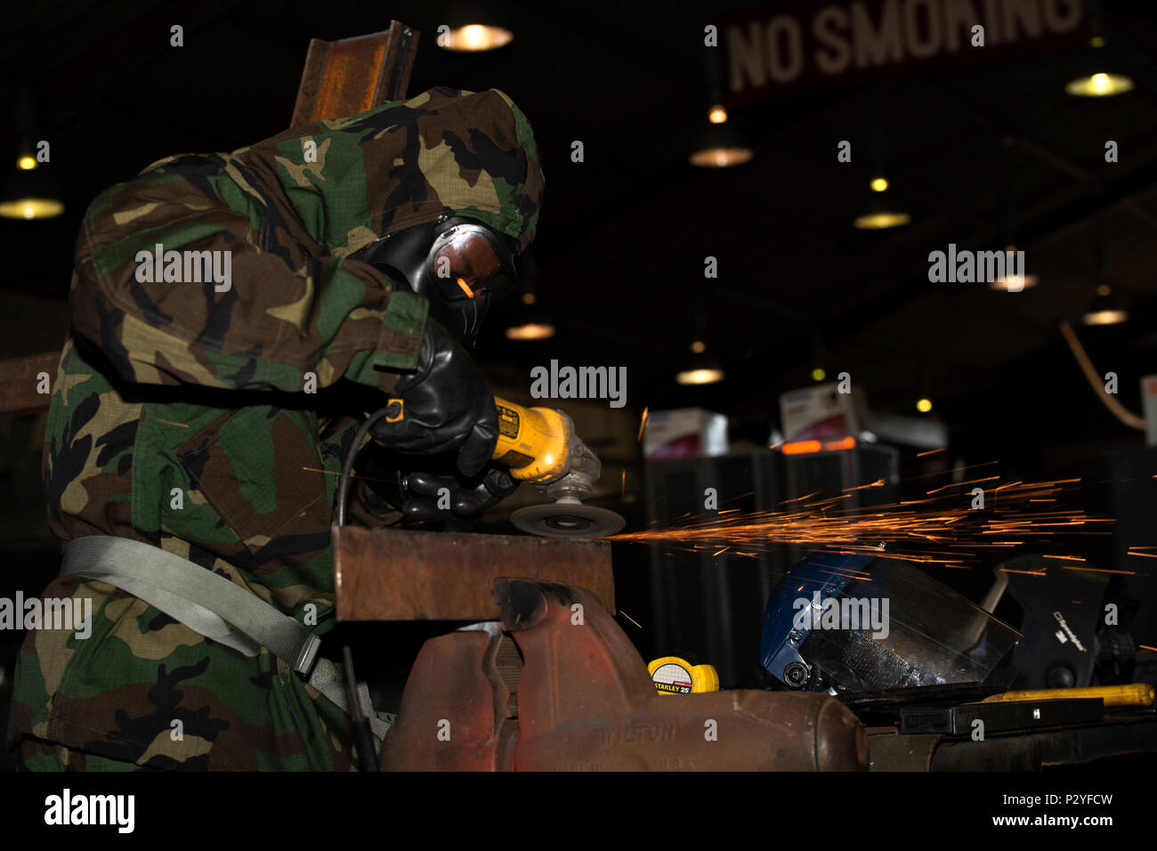 Us Marine Corps Lance Cpl. Trevon Bruce, ein Metall Arbeiter mit der Bekämpfung der Logistik Unternehmen 36, schleift Stahl bei chemischen, biologischen, radiologischen und nuklearen Verteidigung Ausbildung bei der Marine Corps Air Station Iwakuni, Japan, 10.08.2016. Marines, der bereits in der Mission Oriented schützende Haltung, Gang, wurden ausgewertet auf ihre Fähigkeit, effektiv erkennen, melden reagieren und agieren in einer simulierten CBRN-Umgebung. Wenn das Signal "Gas, Gas, Gas, "Marines Rührei M 50 Joint Service Allgemeine Masken zu Don, bevor Sie zu arbeiten, als wenn alles normal war. (U.S. Marine Corps pho Stockfoto