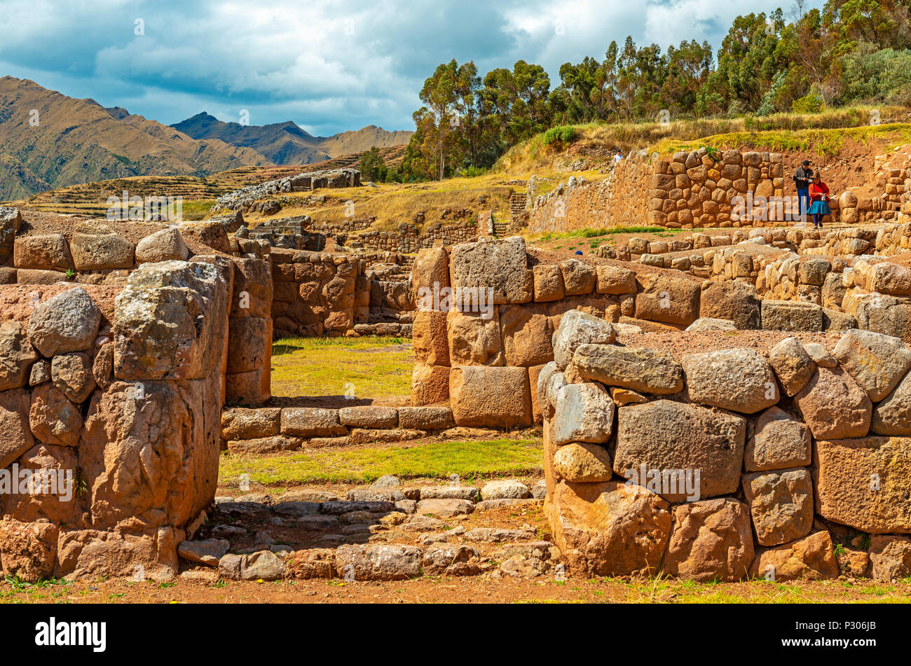 Einer indigenen Quechua Paar in der Inka-ruinen von Chincheros mit einem dramatischen Himmel im Hintergrund in der Nähe der Stadt Cusco, Peru, Südamerika. Stockfoto Einer indigenen Quechua Paar in der Inka-ruinen von Chincheros mit einem dramatischen Himmel im Hintergrund in der Nähe der Stadt Cusco, Peru, Südamerika. Stockfoto