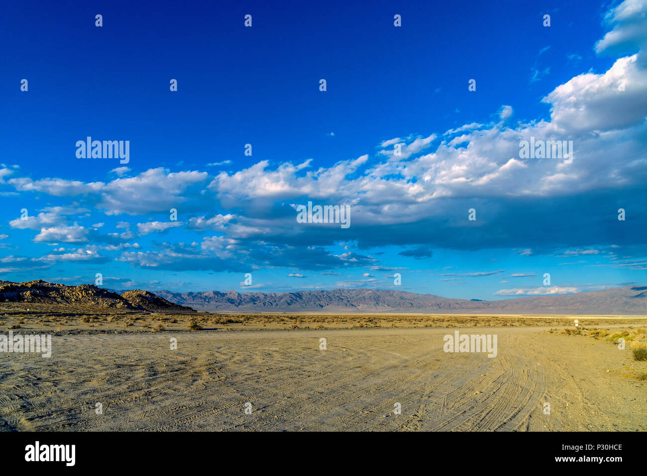 Heiße, trockene Wüste unter einem blauen Himmel mit Wolken. Stockfoto