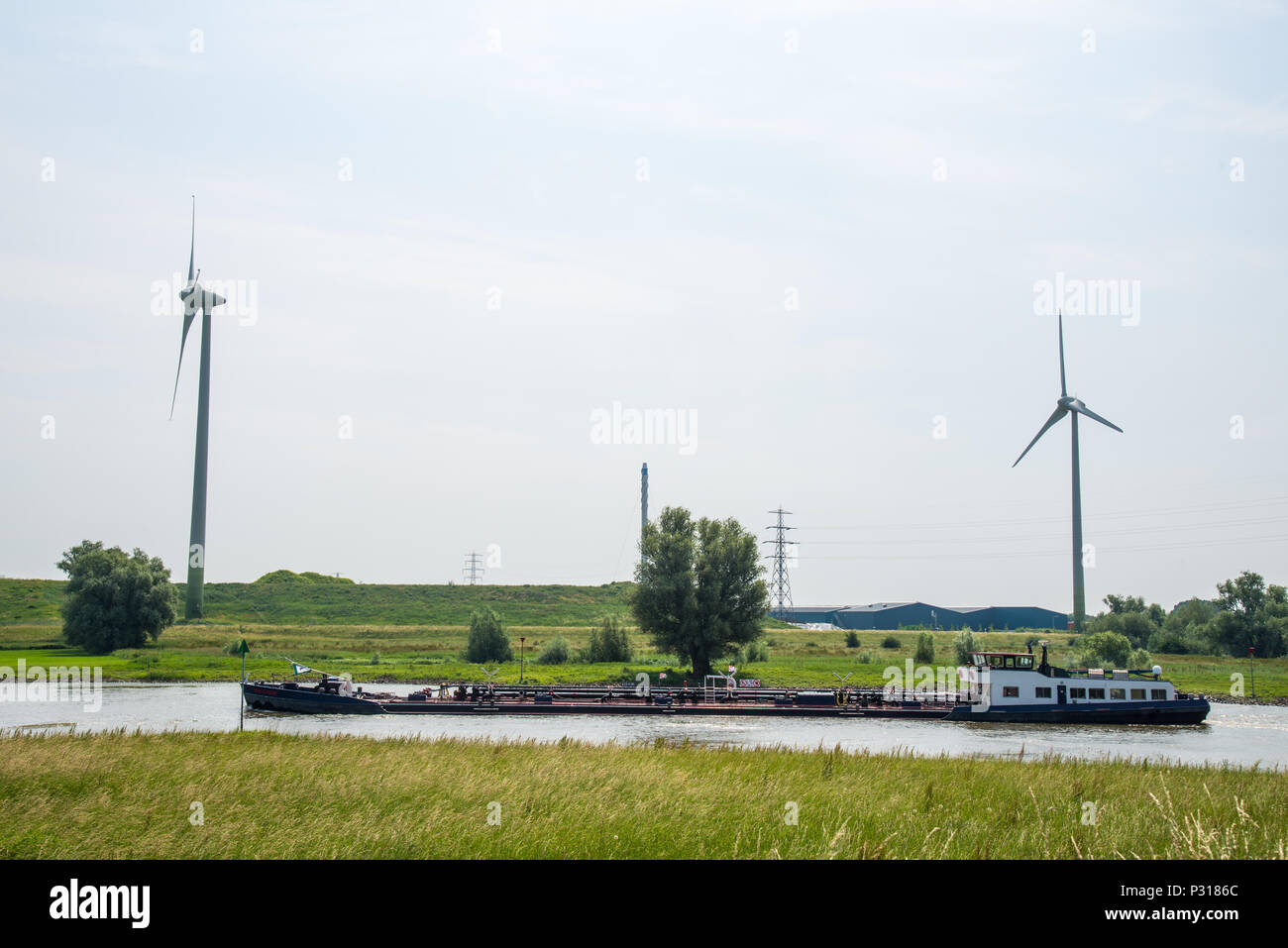 Boot am Fluss IJssel und Windmühlen in Overijssel, Niederlande Stockfoto