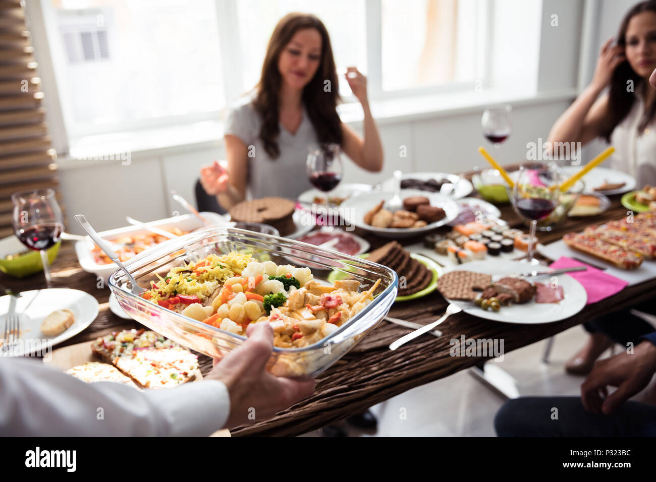 Nahaufnahme von einem Kellner bringen neue Schale mit frischem Essen auf den Tisch Stockfoto