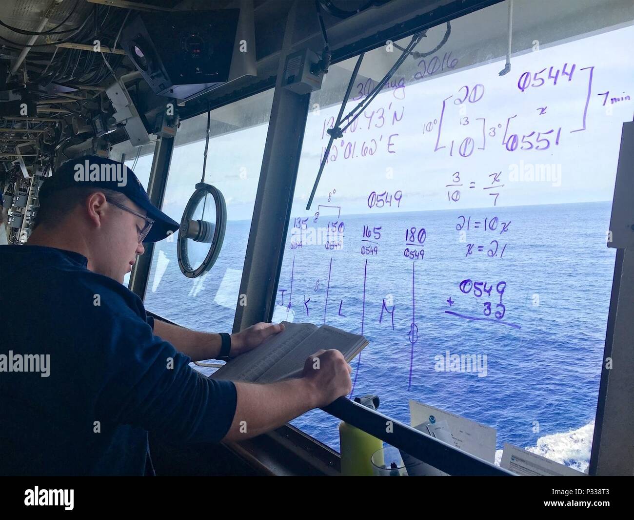 Petty Officer 2nd class William Myers, ein Elektronik Techniker an Bord USCGC Sequoia (WLB-215), verwendet die Nautical Almanac Sonnenuntergang auf See in den Pazifischen Ozean August 30, 2016 zu bestimmen. Trotz vorhandener Elektronik Besatzungen auf See Praxis und erhalten grundlegende Seemannschaft Fähigkeiten. (U.S. Coast Guard Foto von Chief Petty Officer Sara Mooers) Stockfoto