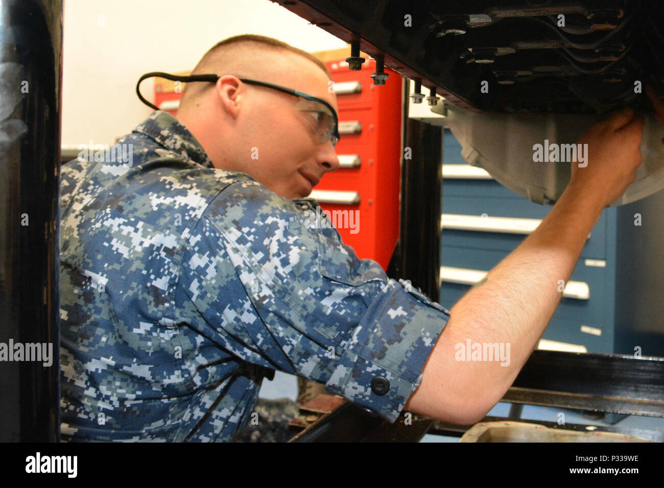 Seaman Jakob Pruett reicht in die Zylinder eines Marine Diesel Motor die Pleuelstange und den Kolben vorsichtig nach unten zu führen. Pruett arbeitet im Diesel Shop am Südosten regionale Maintenance Center (SERMC). Enginemen zu betreiben, zu warten und Verbrennungsmotoren, Hauptantriebsmaschinen, Kälteanlagen, Klimaanlagen, Gas trubine Motoren und andere Zusatzgeräte an Bord Navy Schiffe reparieren. Stockfoto