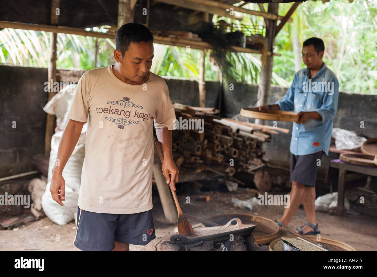 Master Röster manuell geröstete Kaffeebohnen über einen Holzofen in der Nähe von Banyuwangi, Java, Indonesien Stockfoto