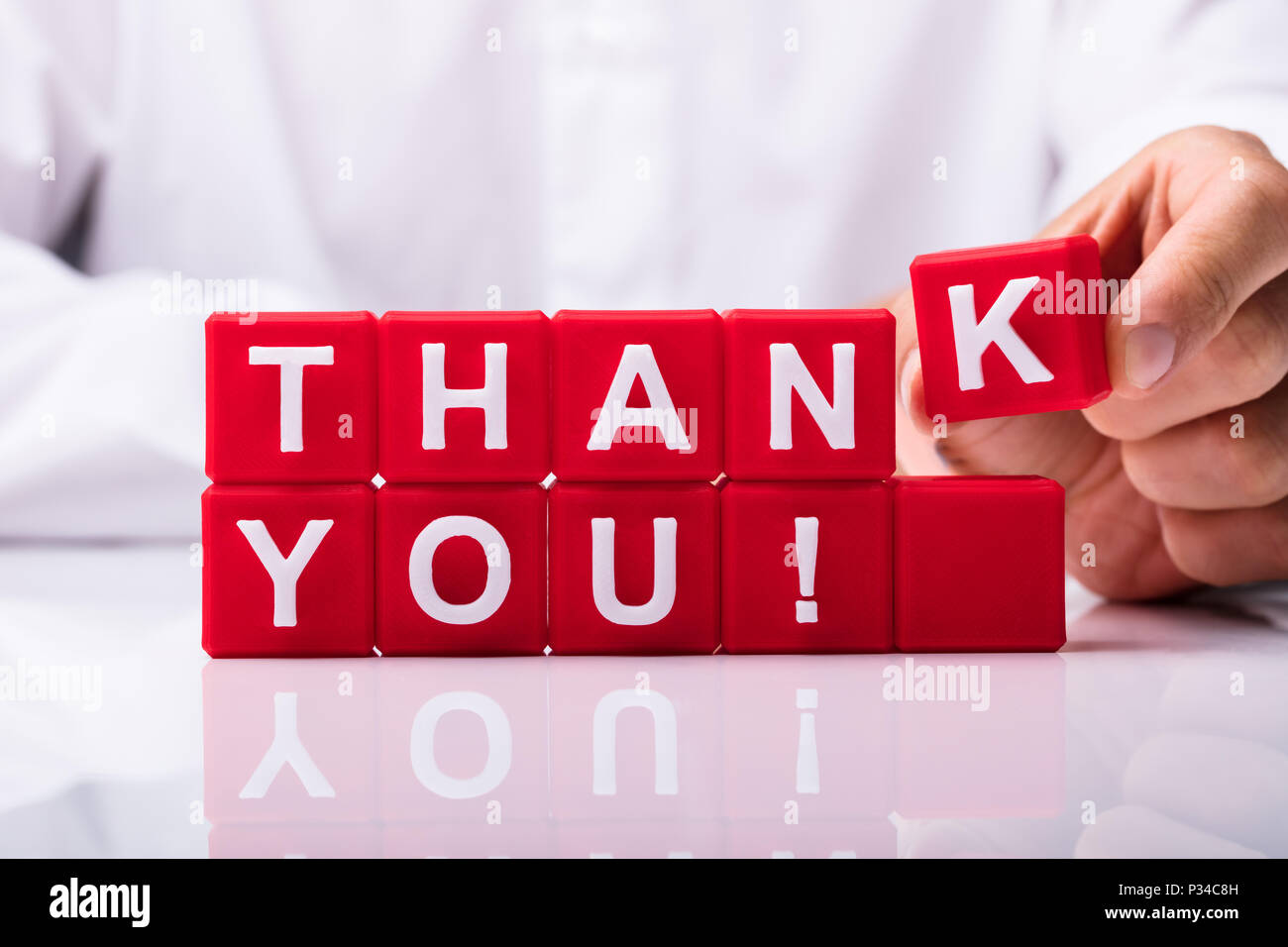 Nahaufnahme von einer Person Hand Danke Text mit Roten würfelförmige Blöcke Stockfoto