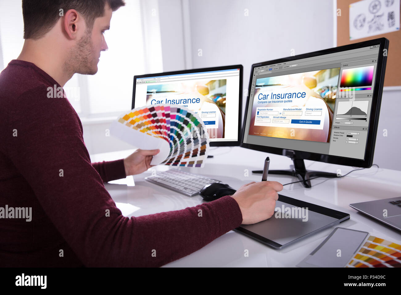 Seitenansicht eines jungen männlichen Designer halten bunte Swatch Arbeiten am Computer im Büro Stockfoto