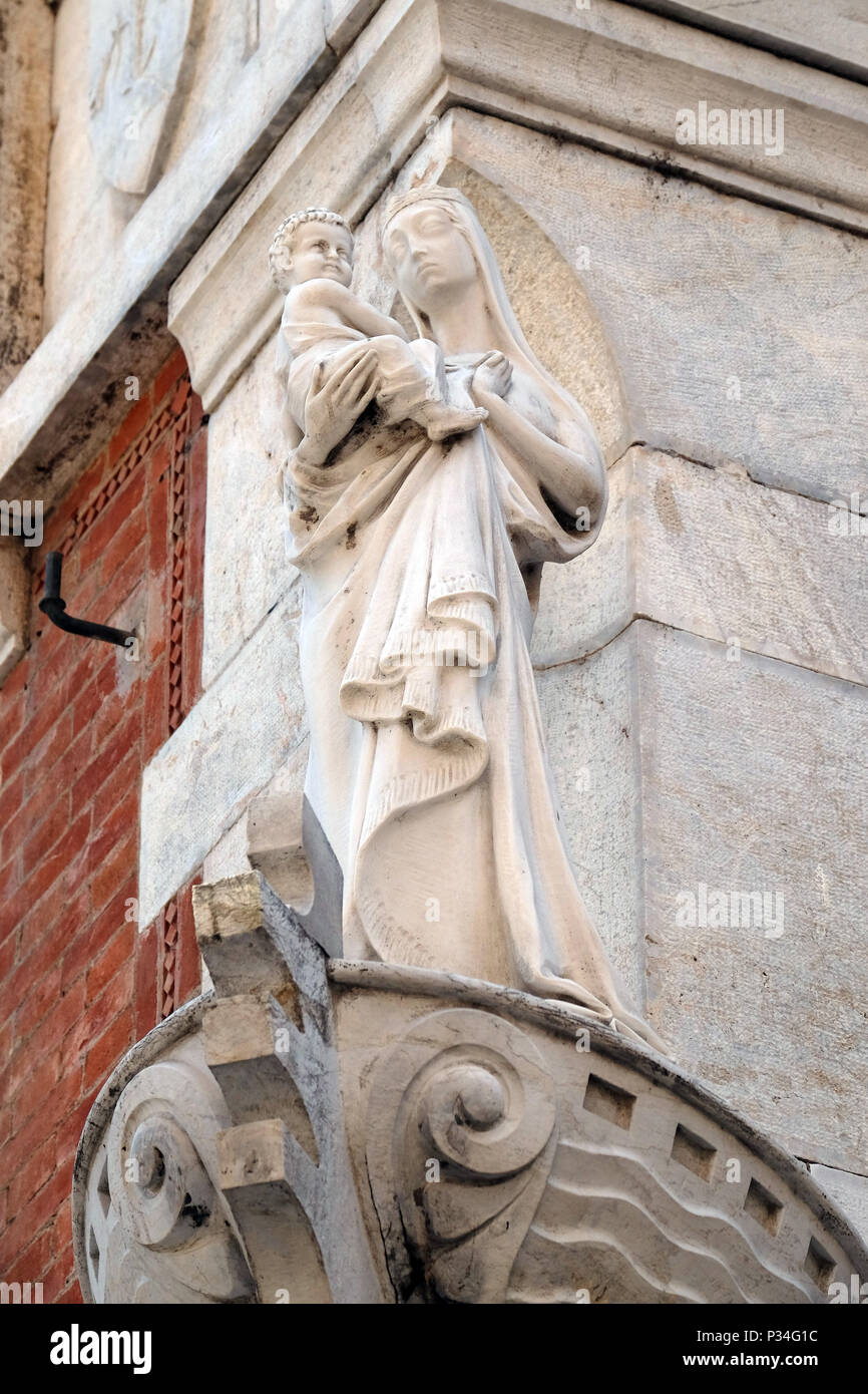 Statue der Jungfrau Maria mit dem Jesuskind auf der Hausfassade in Lucca, Toskana, Italien Stockfoto