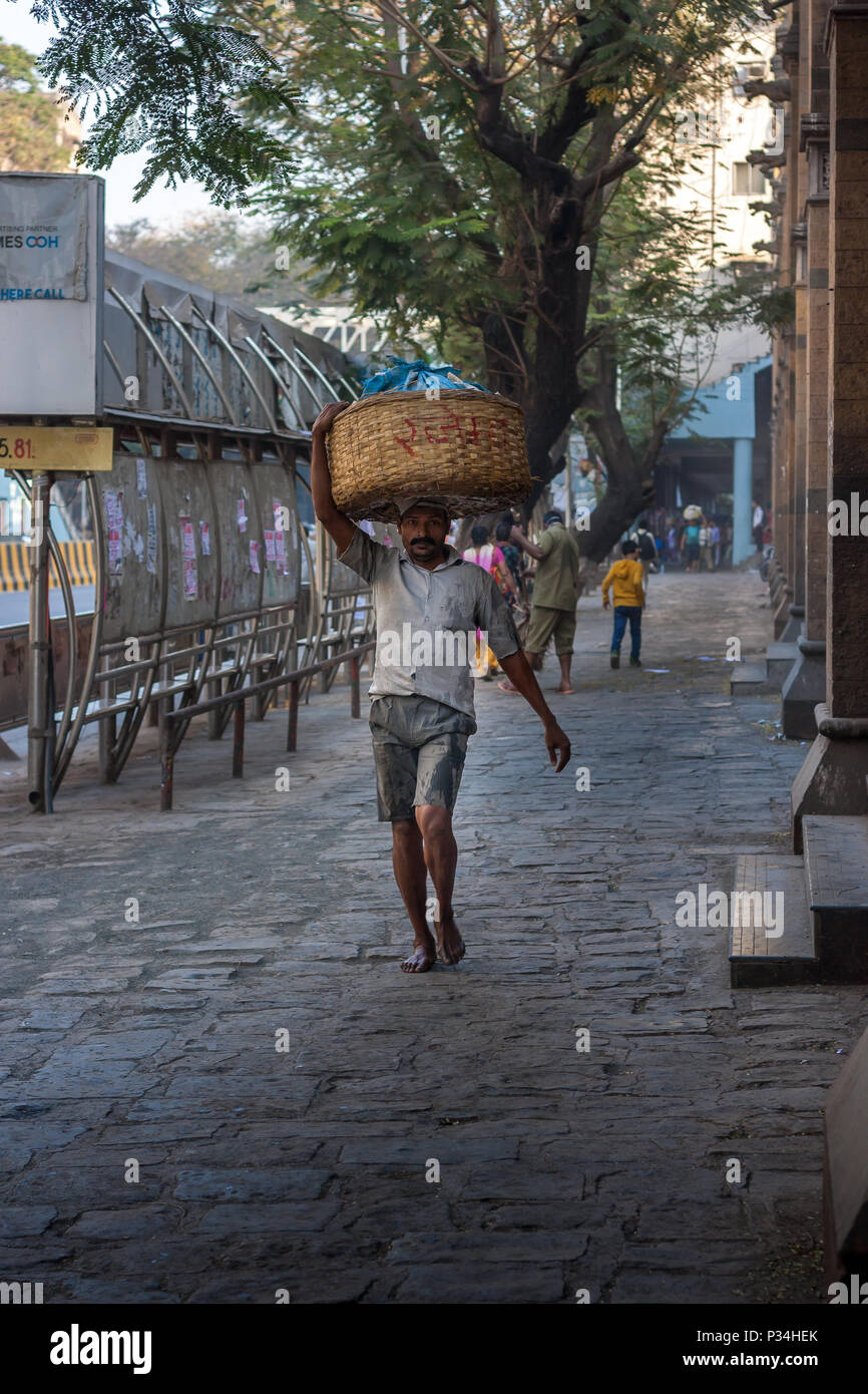 MUMBAI, INDIEN - Januar 29, 2017: unbekannter Mann carryng Gewicht auf seinem Kopf - ein Eimer voller frischer Fisch Stockfoto