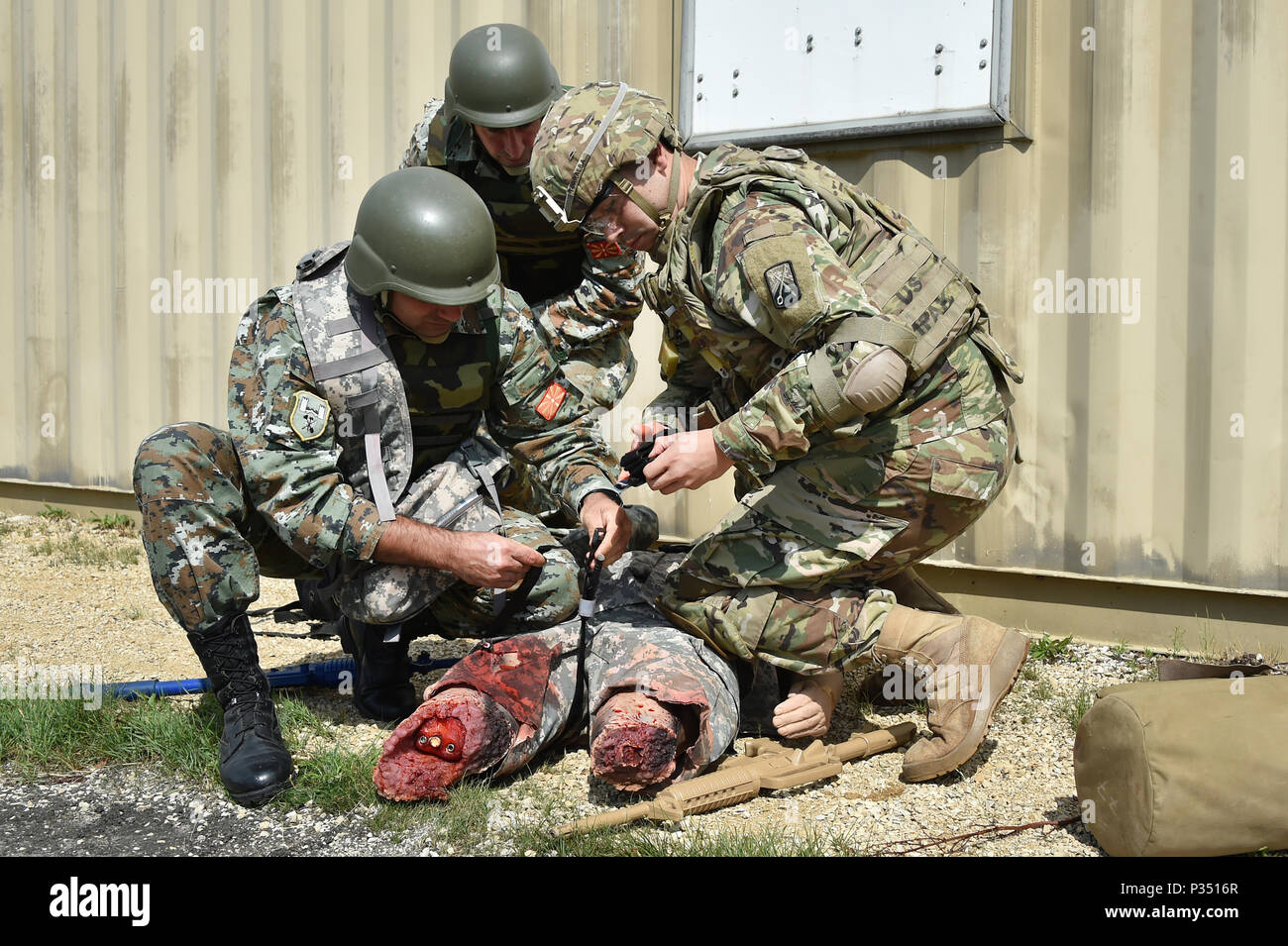 Von rechts nach links, ein US-Soldat und zwei Soldaten aus Mazedonien erste Hilfe bei einem simulierten Unfall an der Medizinischen Simulationen Training Center gelten während der 7th Army kombinierte Waffen Training Center (CATC) Bekämpfung der Lebensretter Kurs auf Rose Barracks, Vilseck, Deutschland, 15. Juni 2018. Dieser Kurs vermittelt die unmittelbare, weit nach vorn medizinische Versorgung auf einem weit verstreuten Schlachtfeld während Weitere medizinische Behandlung und Evakuierung wartet. (U.S. Armee Foto von Gertrud Zach) Stockfoto