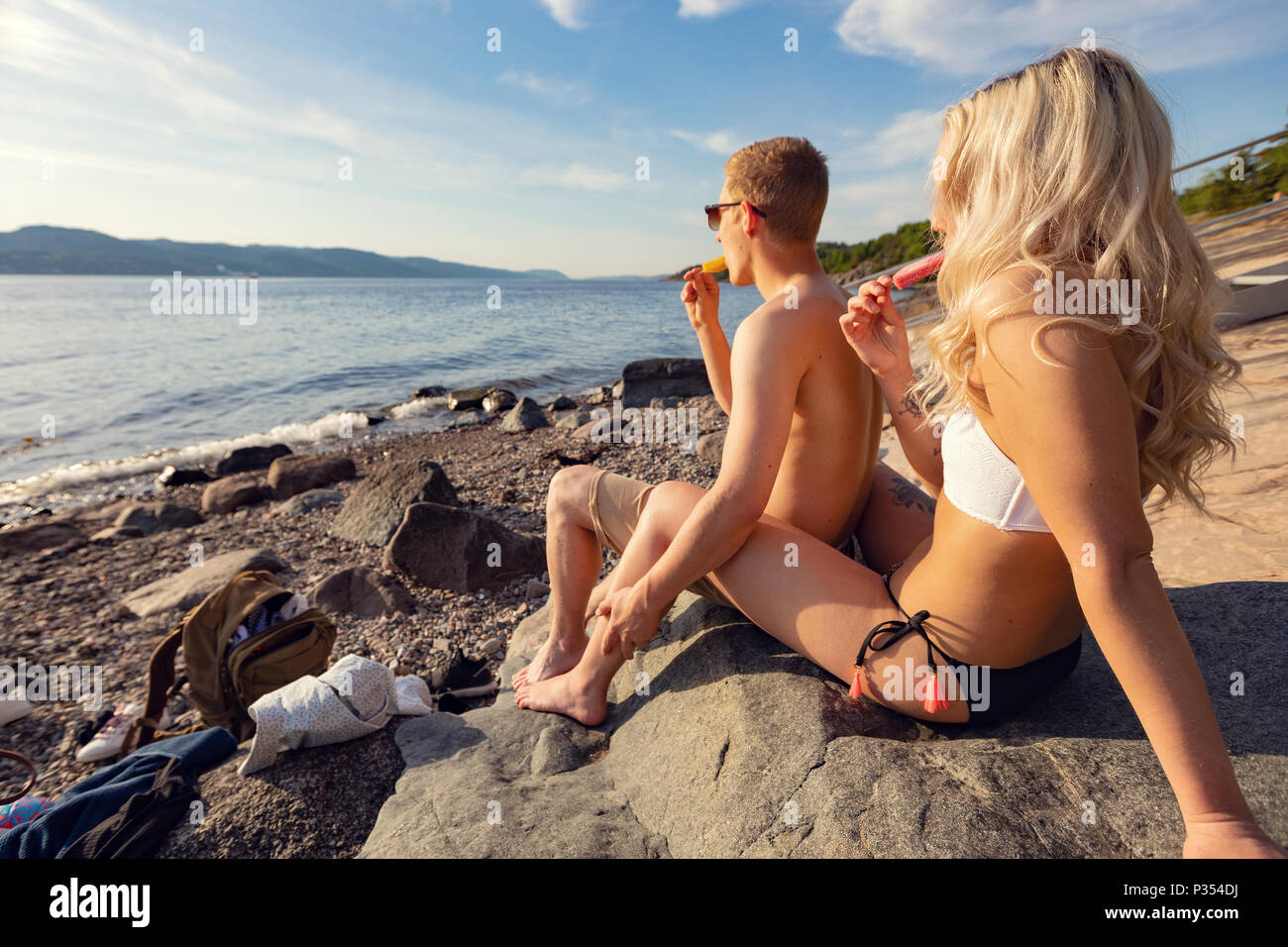 Paar kalten Eis am sonnigen Strand genießen Stockfoto