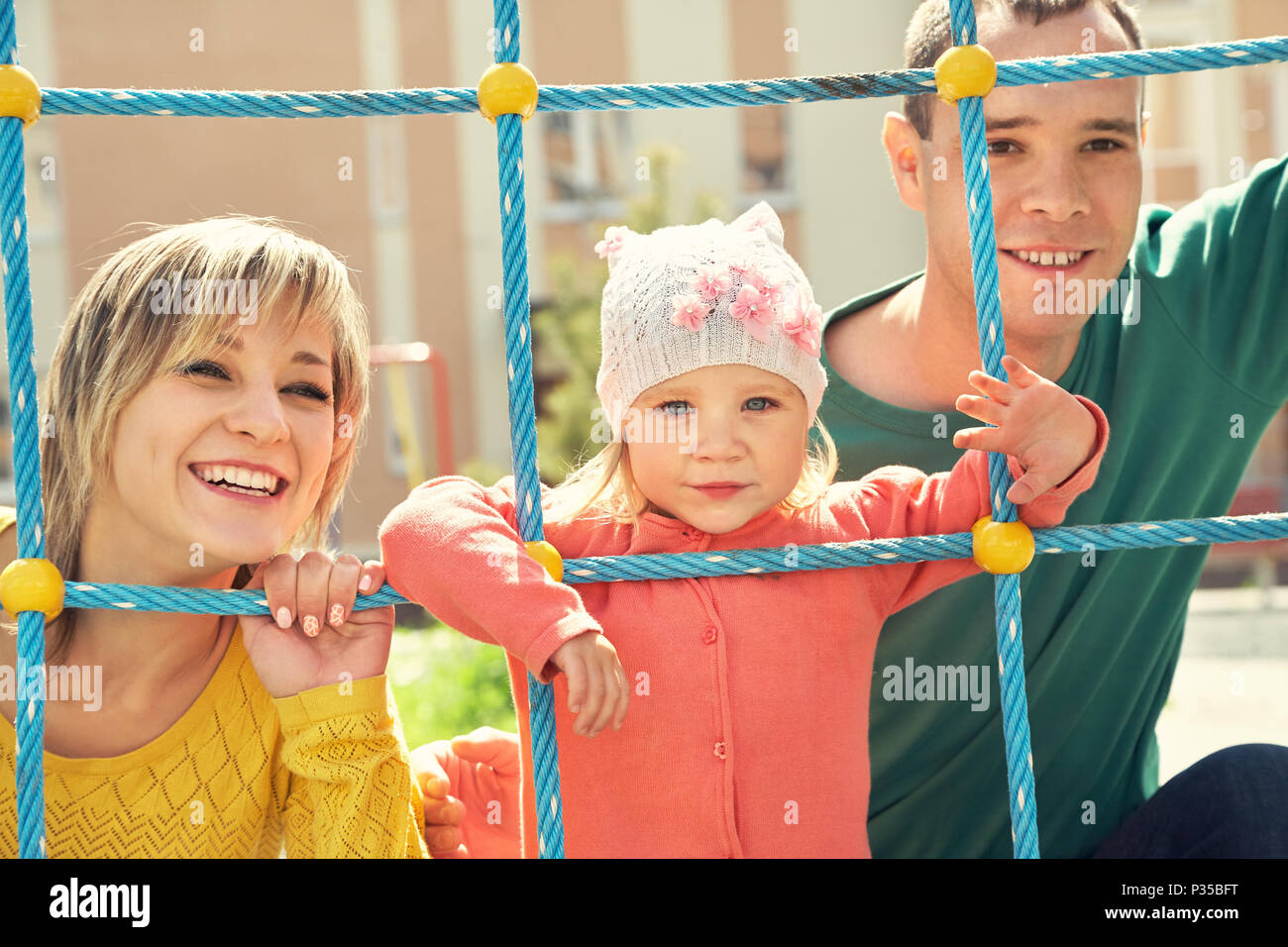 Kind mit Eltern auf dem Spielplatz Stockfoto